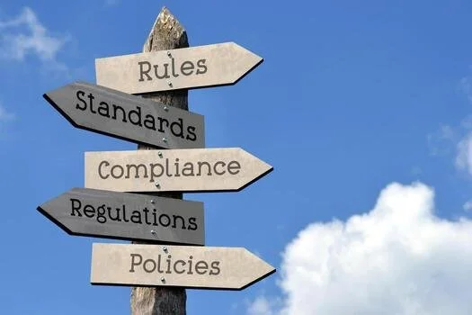 rules-standards-compliance-regulations-policies-wooden-signpost-with-five-arrows-sky-with-clouds-photo.jpg