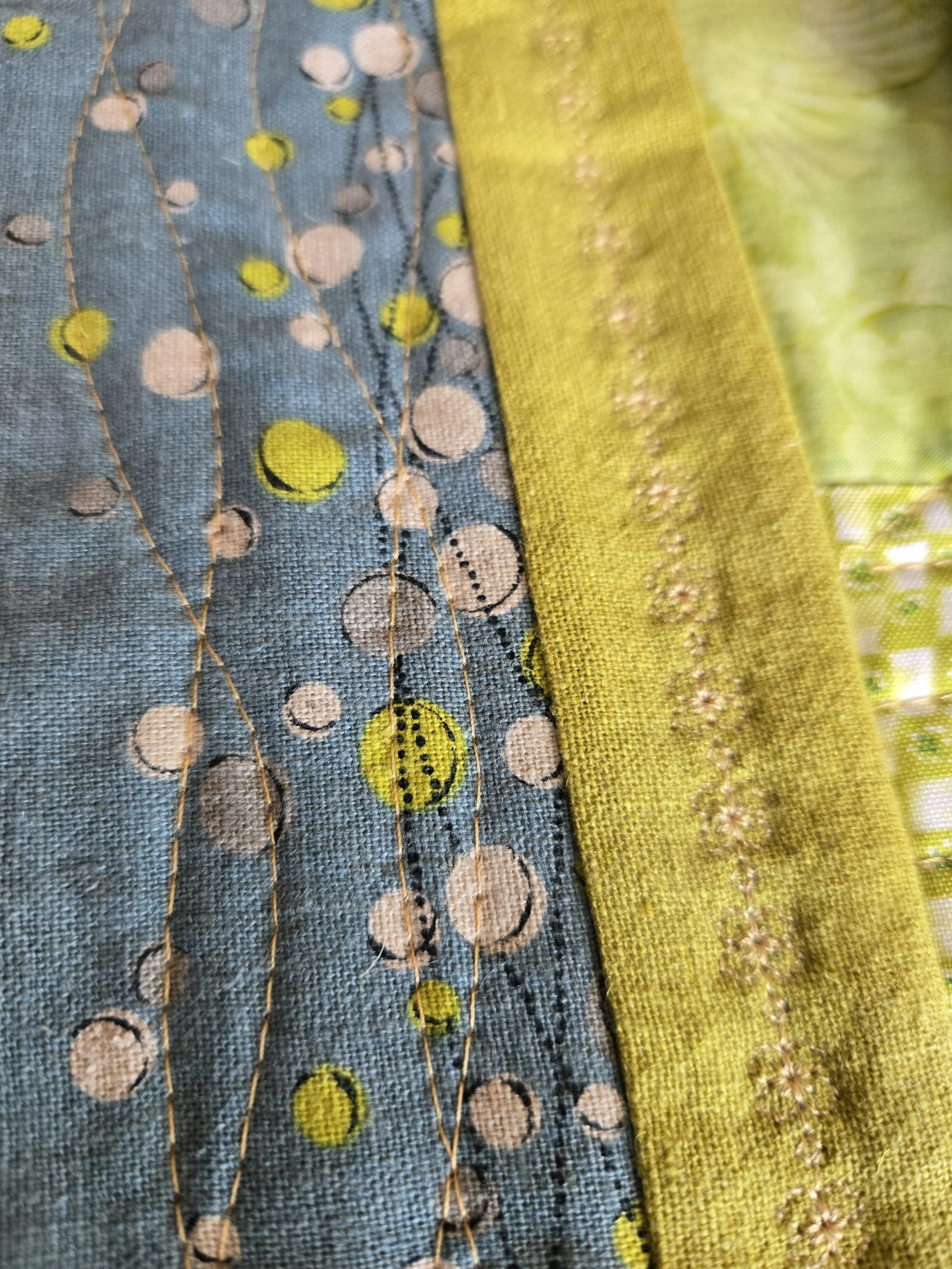 Close-up of various fabric textures and designs, including stitching and embroidered details.