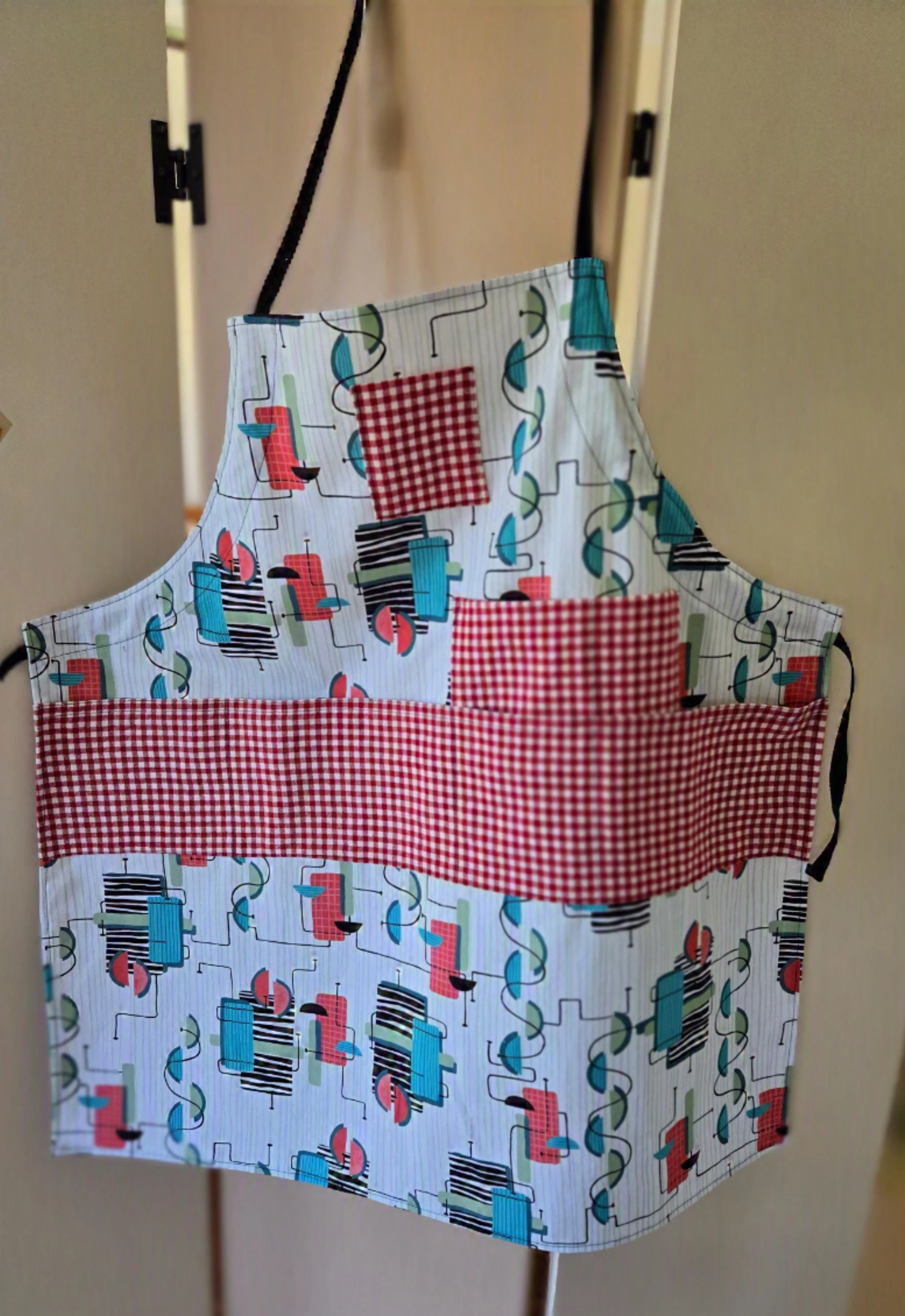 Fabric apron with a colorful abstract pattern and red gingham pocket, for the whimsical client, by dbfourdesign