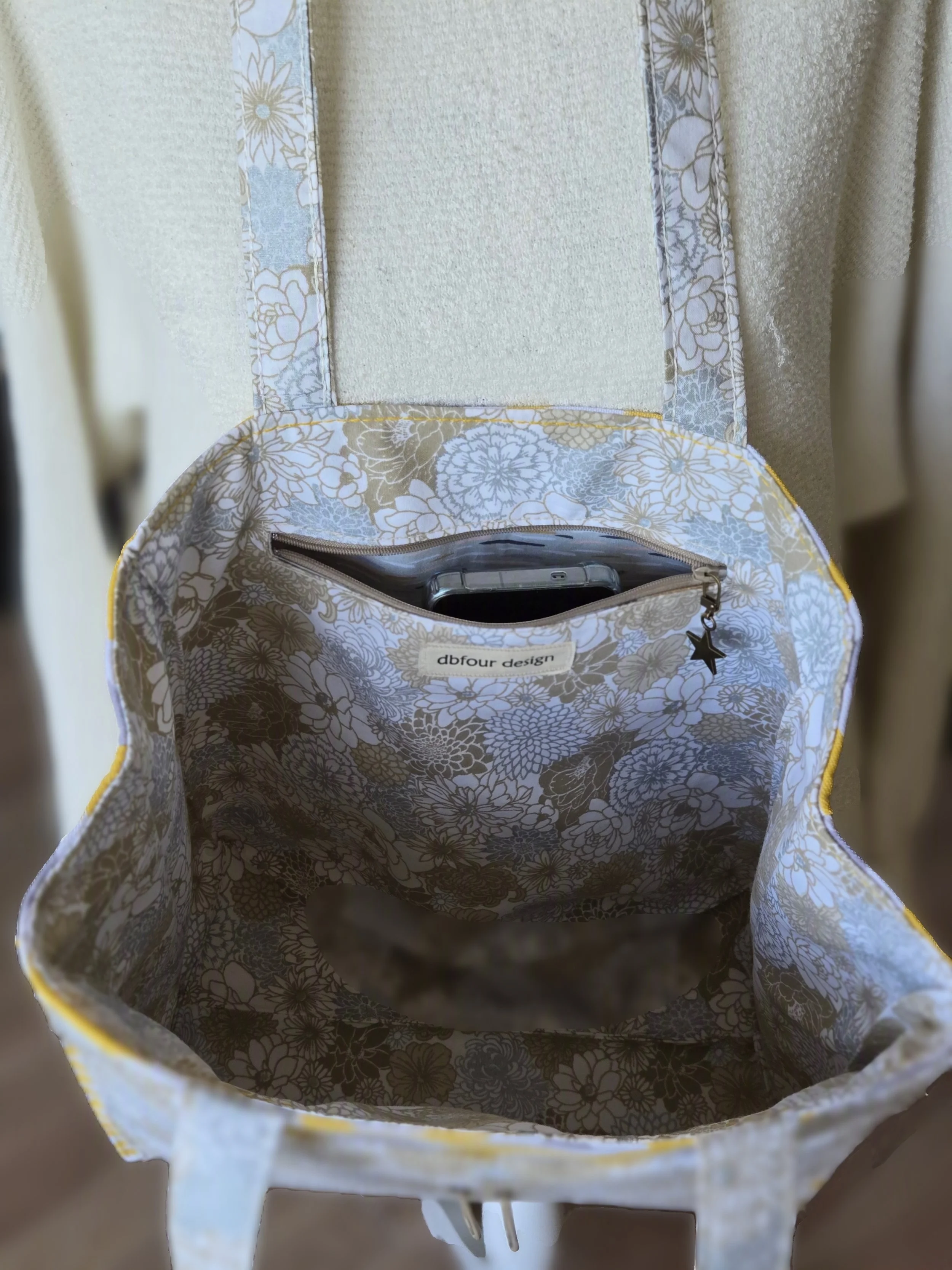Inside of a floral patterned bag with a small zipper pocket containing a smartphone, practical with a little style by dbfourdesign