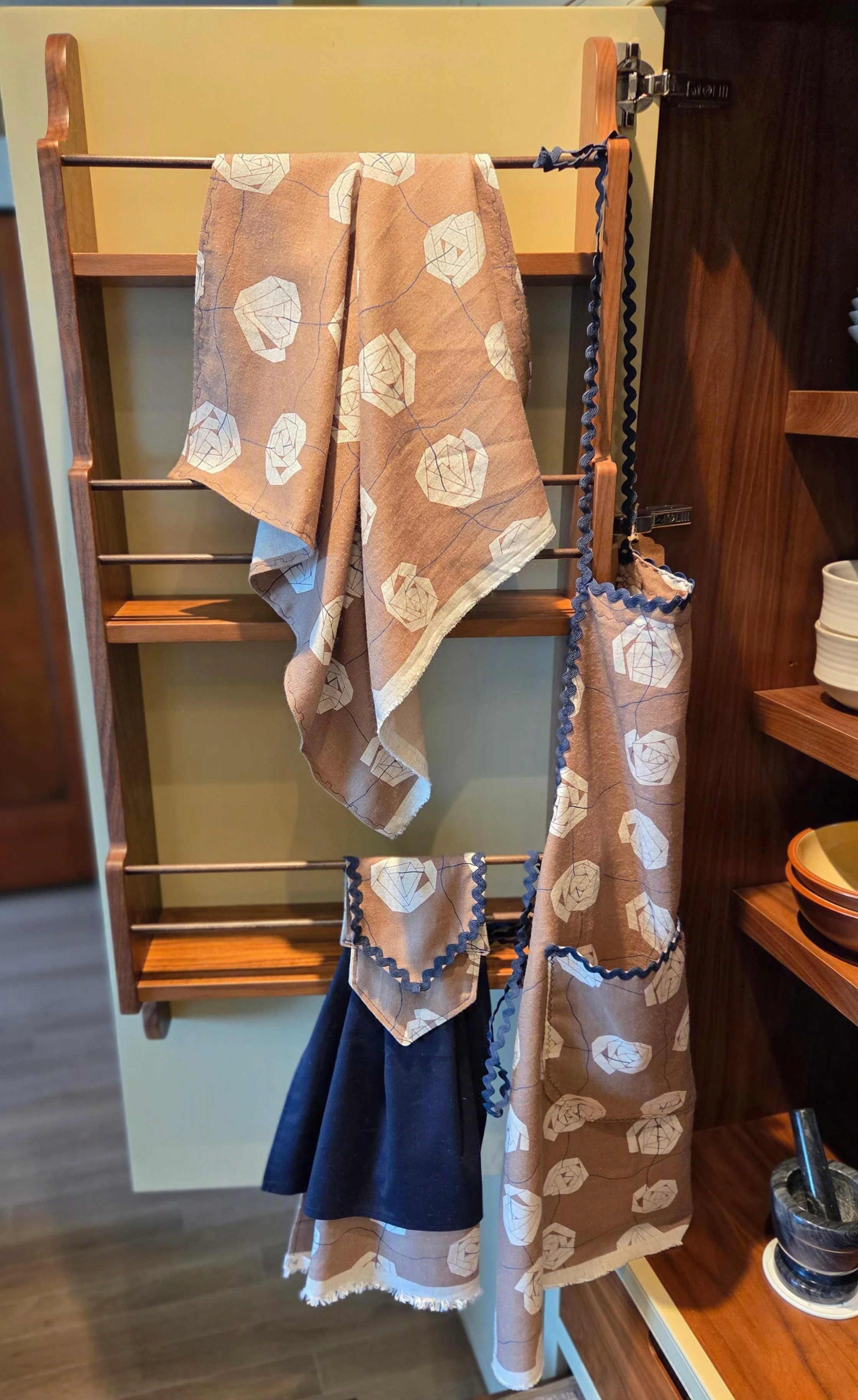 Display of beige kitchen towels and apron good for any kitchen.