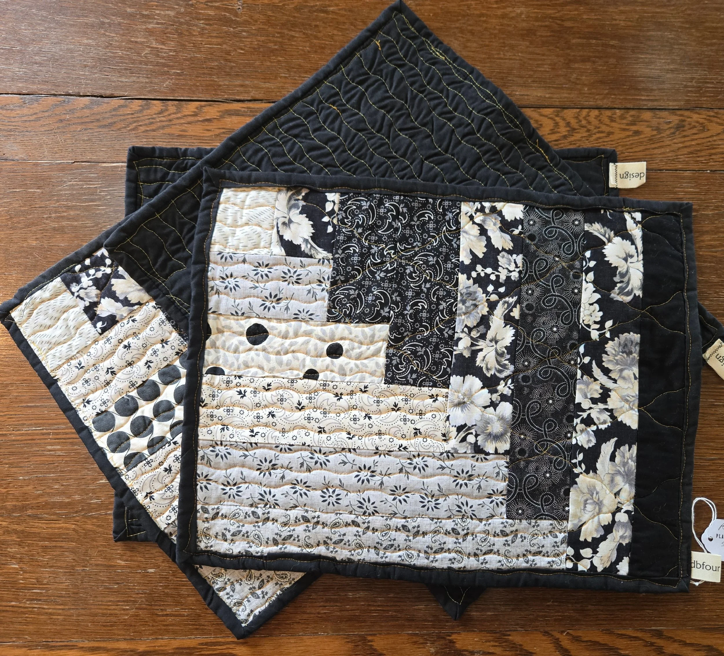 quilted placemats in  black, beige, and white floral and geometric patterns
