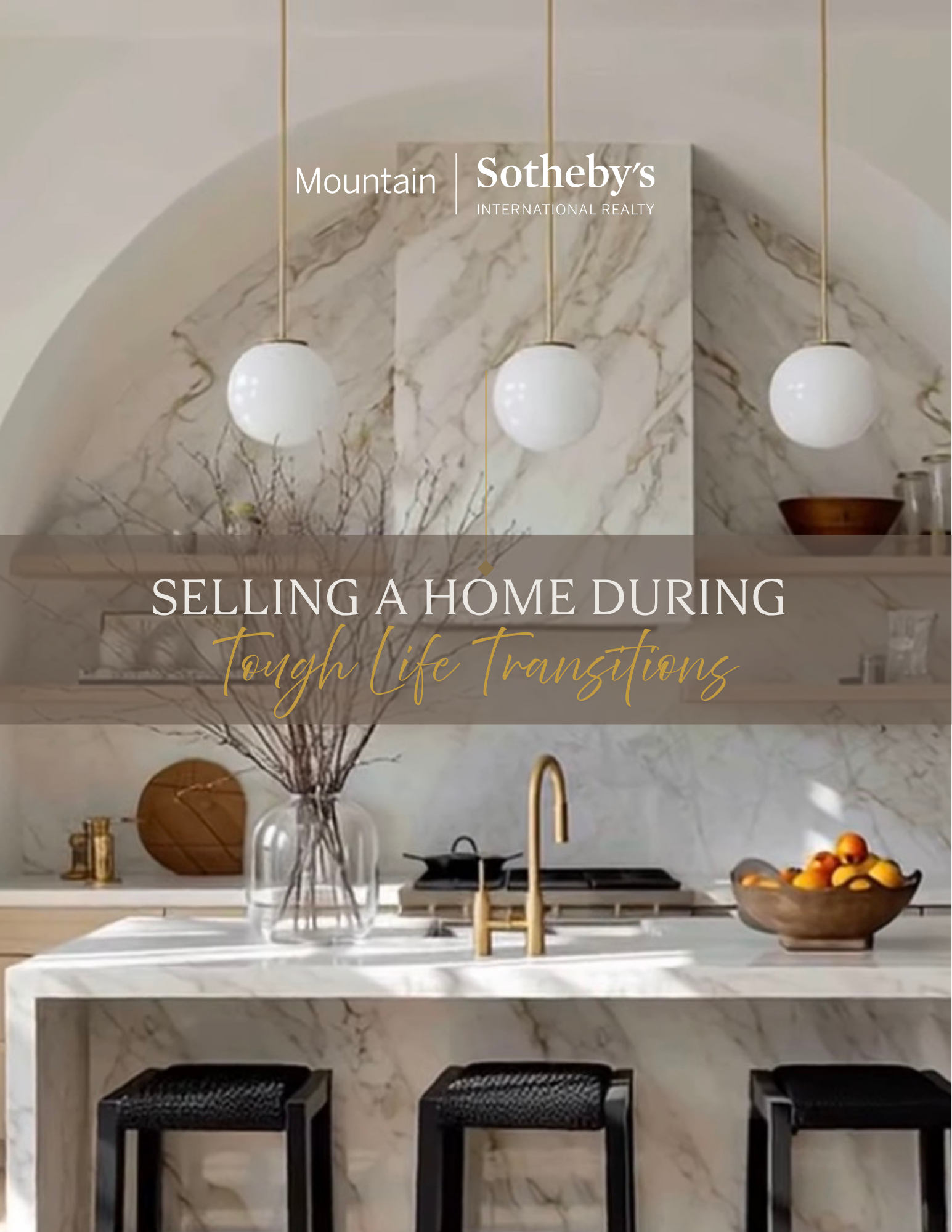 Modern kitchen with marble countertops and backsplash, three white pendant lights, a vase with branches, a wooden bowl with fruit, and black bar stools.