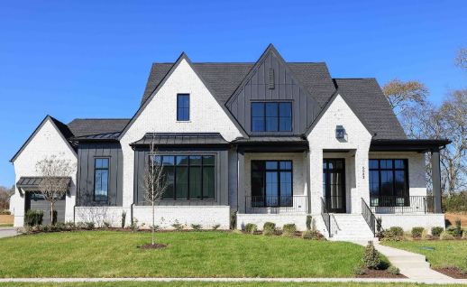 Modern black and white house with large windows and a front yard