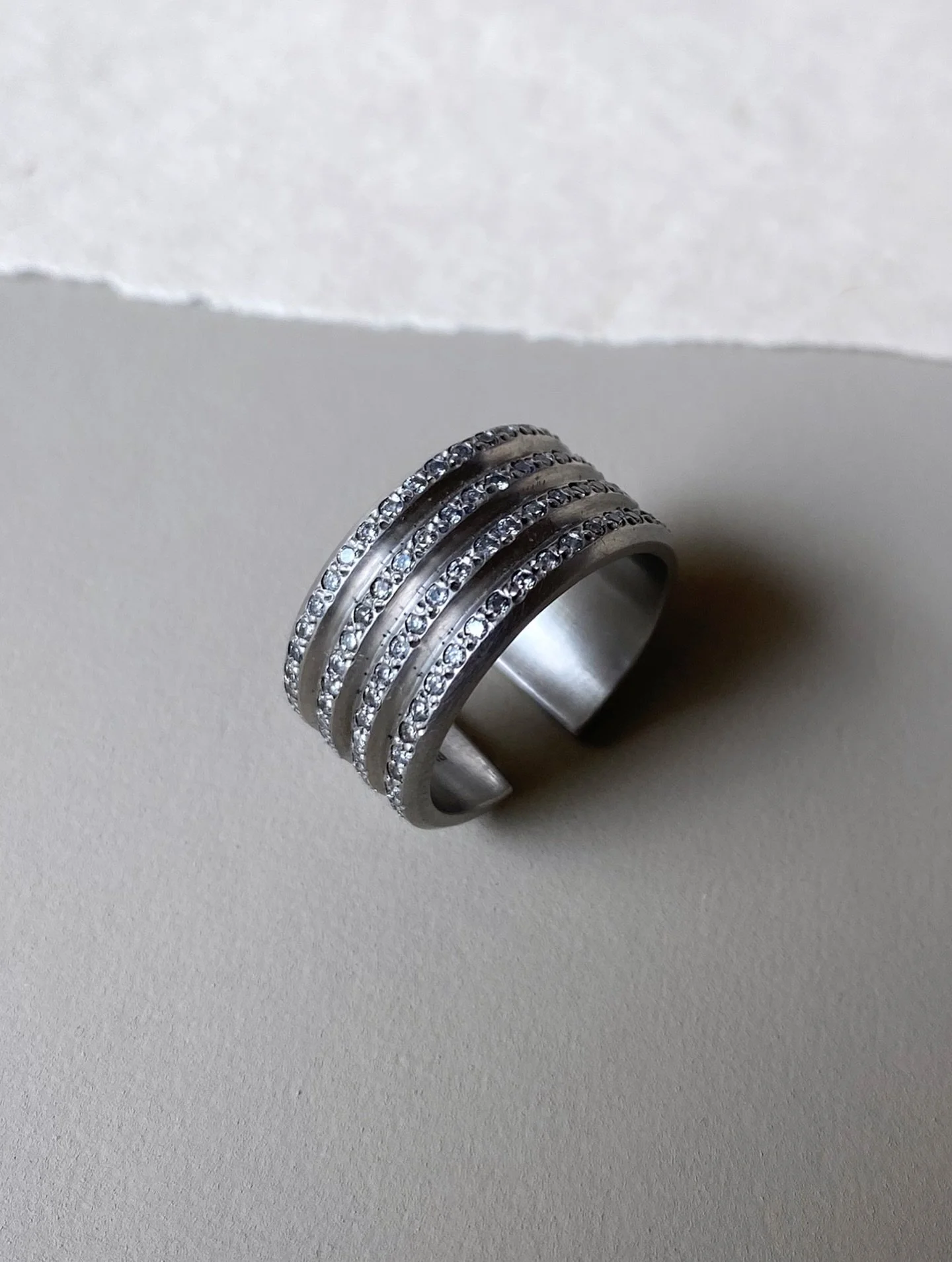 There are always a few pieces that a difficult to let go of.

The Ridge Grey Diamond Ring is one of them 🩶

A sculptural platinum cuff pav&eacute; set with natural grey diamonds, designed to be worn with the opening facing forwards or reversed for a