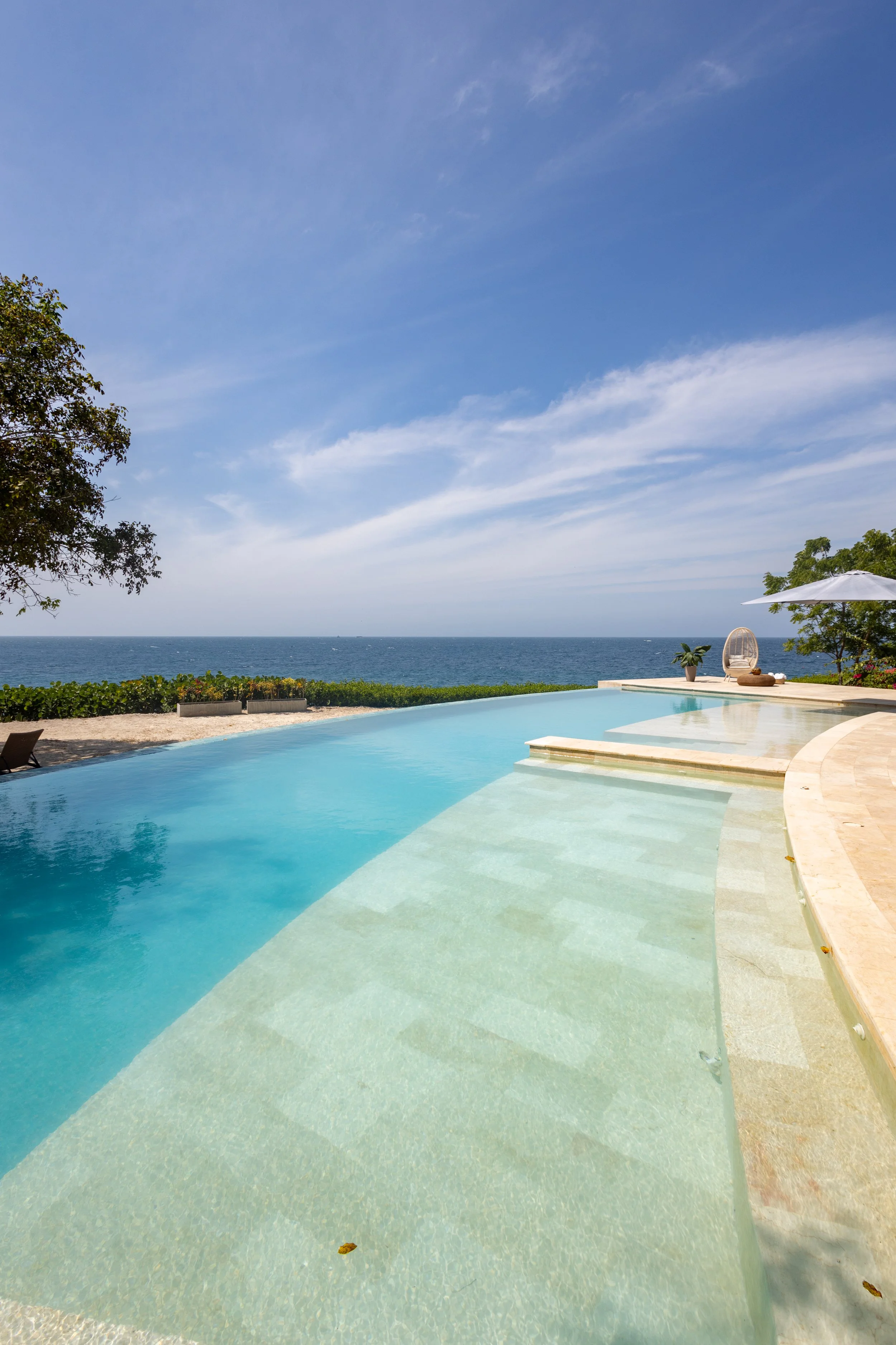 Piscina rodeada de camastros frente al mar Caribe en Cartagena.