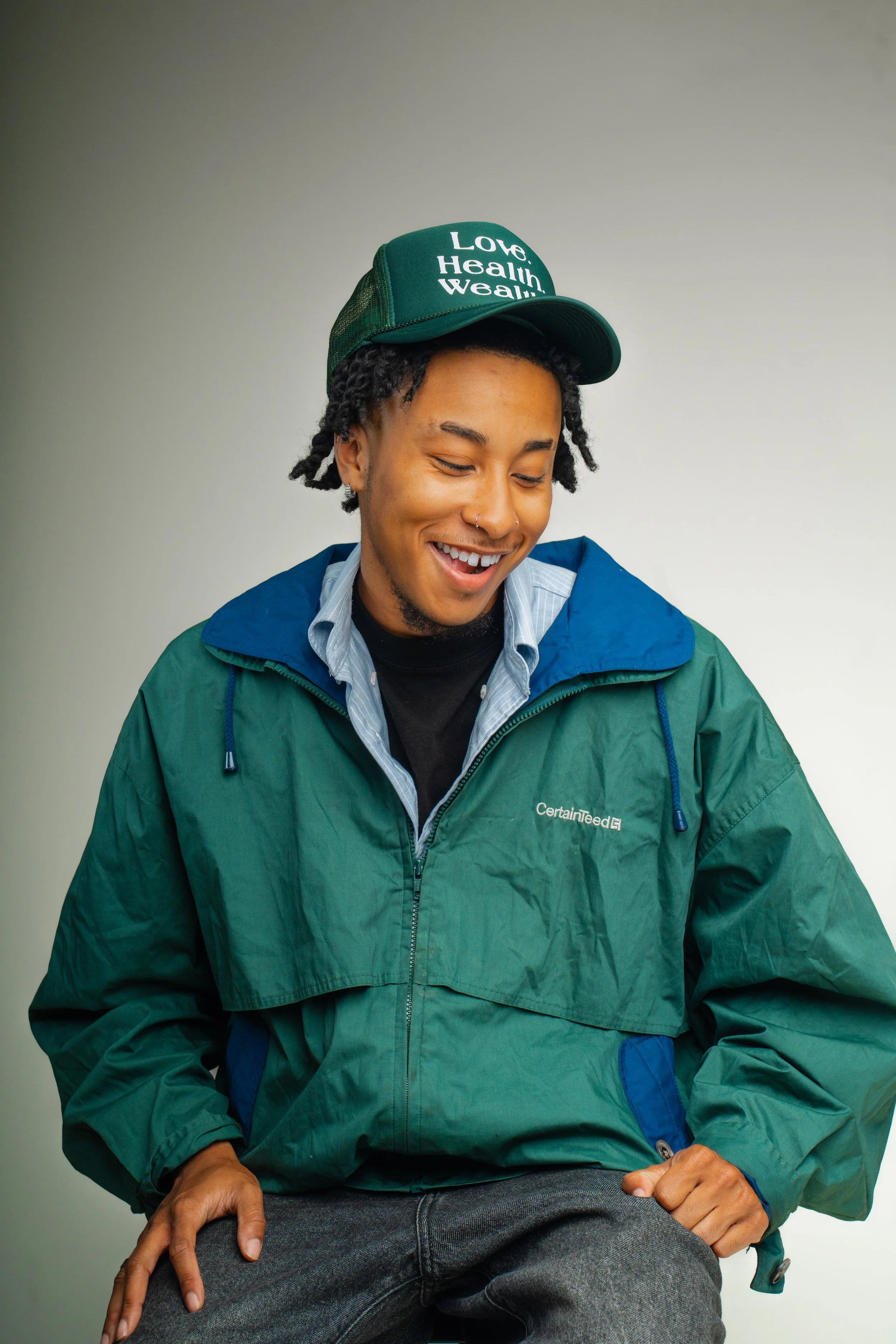Model wearing green Love Health Wealth hat, BOI unisex streetwear