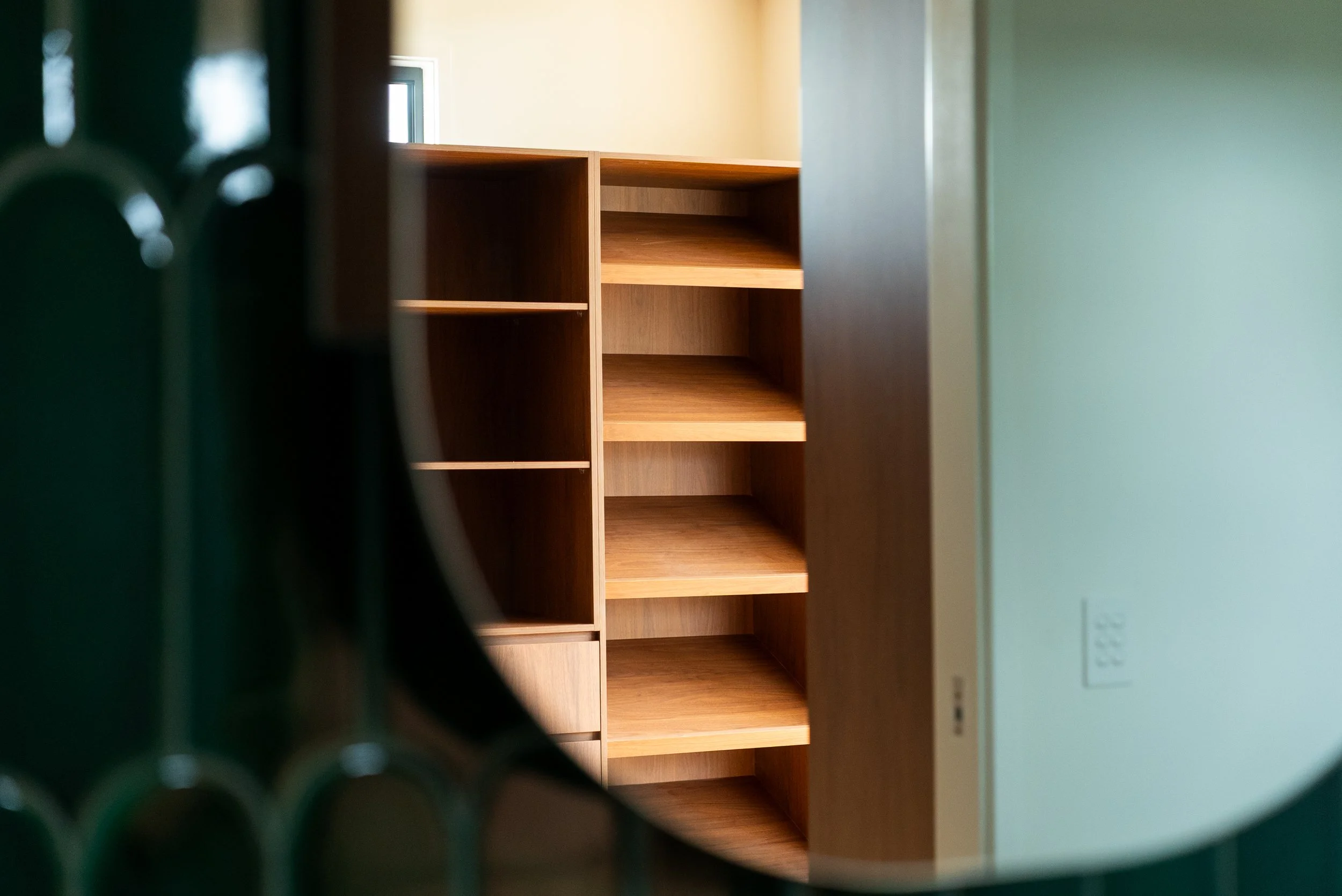 An interior view of wooden shelves seen through a circular peephole.