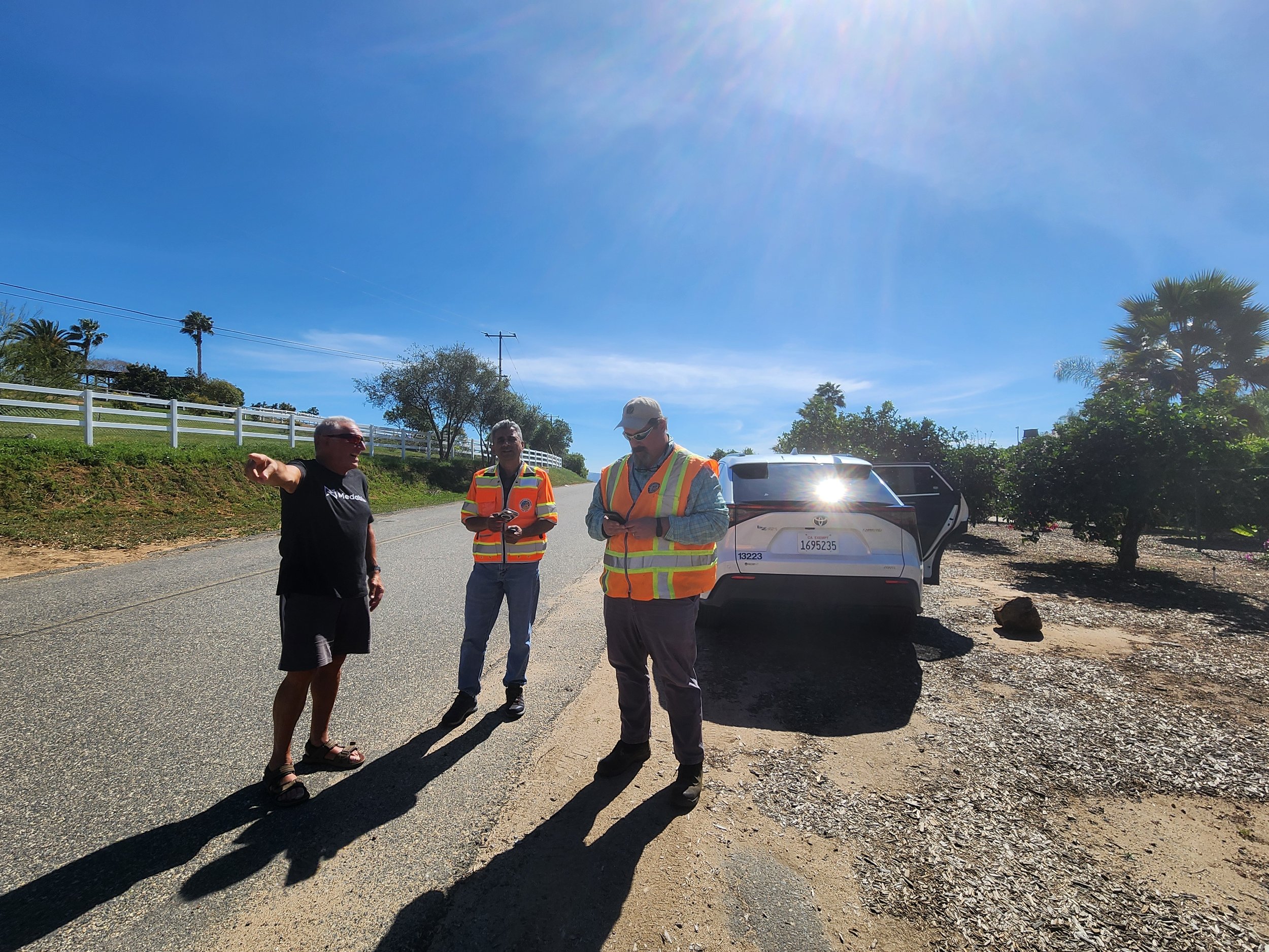 San Diego County Department of Public Works staff and resident Steven Shrewsbury stand on Wilt Road in PRD 13A, Fallbrook, during a site visit discussing road conditions and needed repairs.