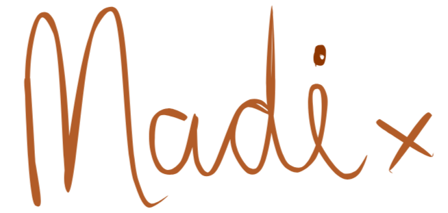 Handwritten signature that says 'Madi' in brown on a black background.