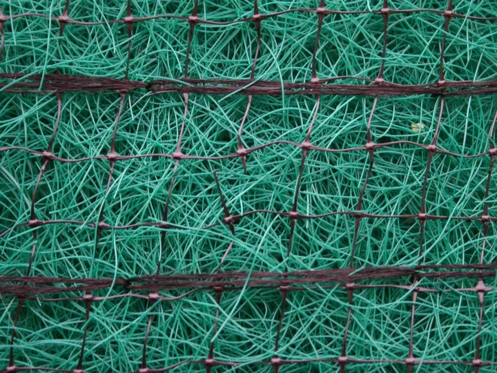 Close-up of green fishing lines tangled inside a red wire mesh fishing trap.