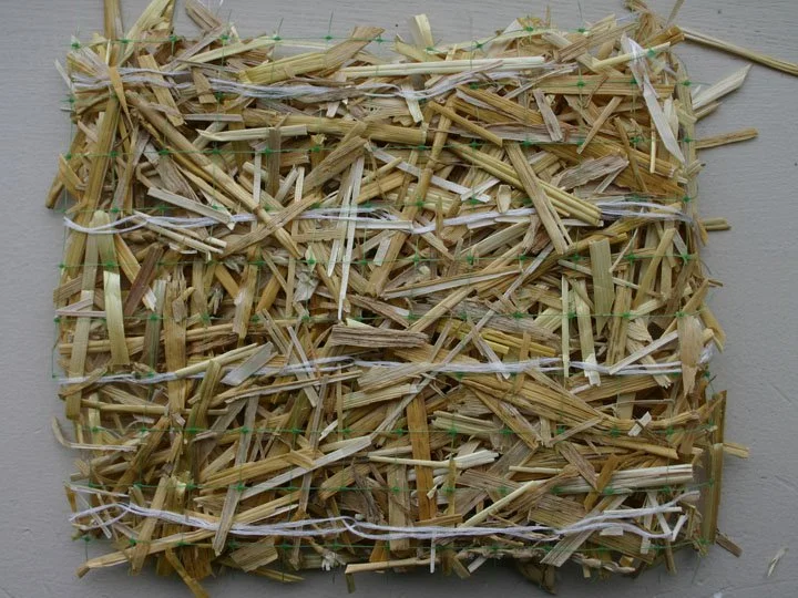 Square piece of straw or hay held together with white string.