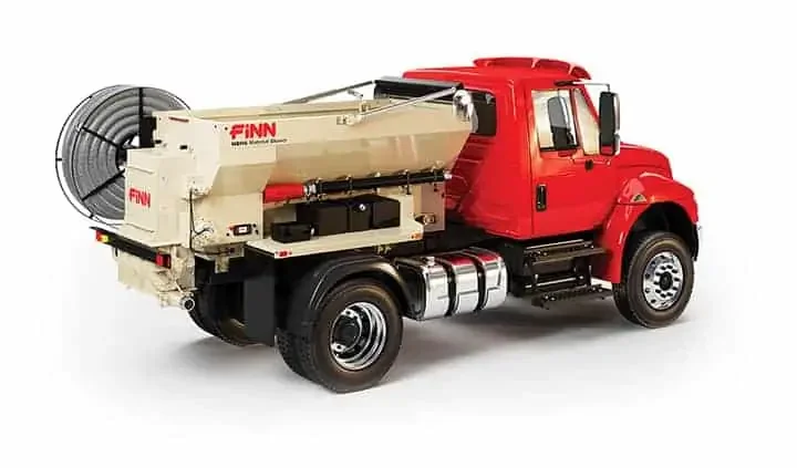 Red fire truck with a large hose reel and firefighting equipment mounted on the side.