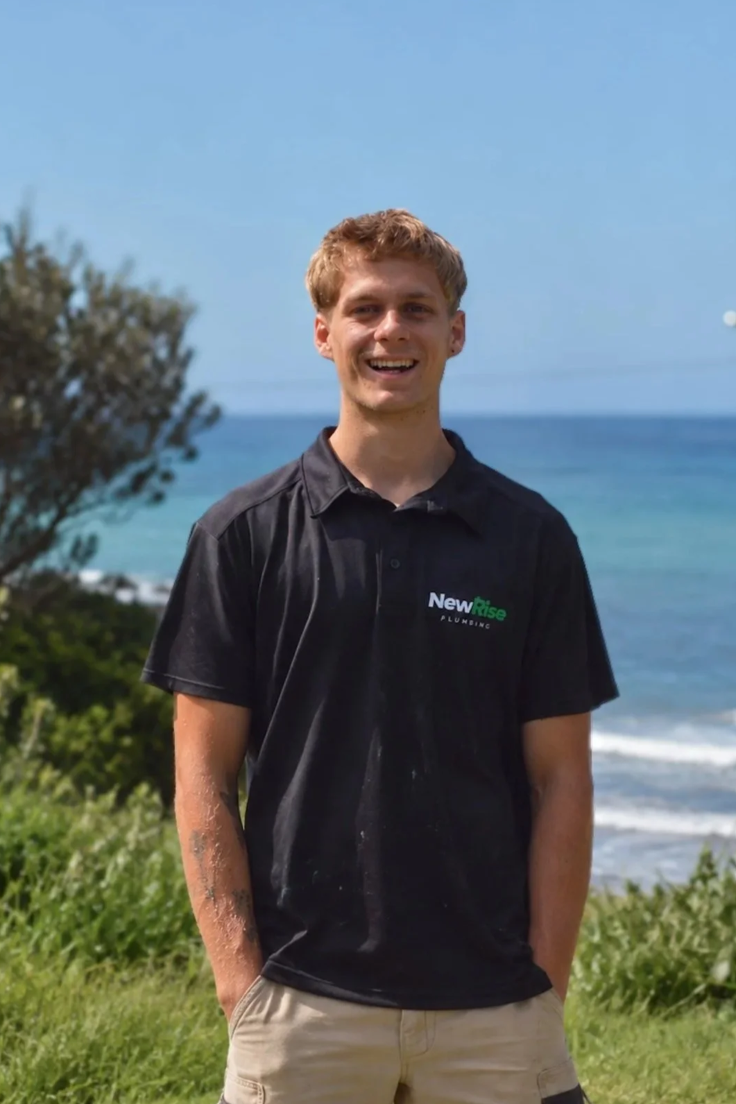 Cooper from NewRise Plumbing standing outdoors near the coast in Sydney