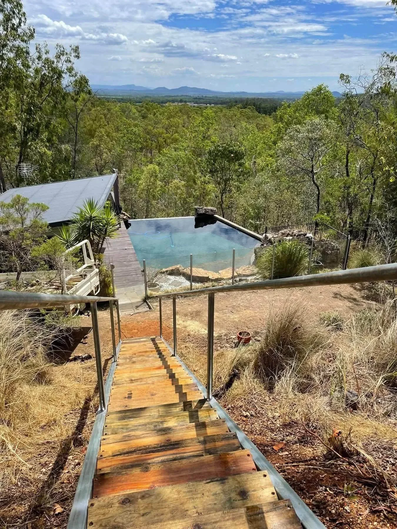 Timber landscape steps providing access to a pool area on a rural property