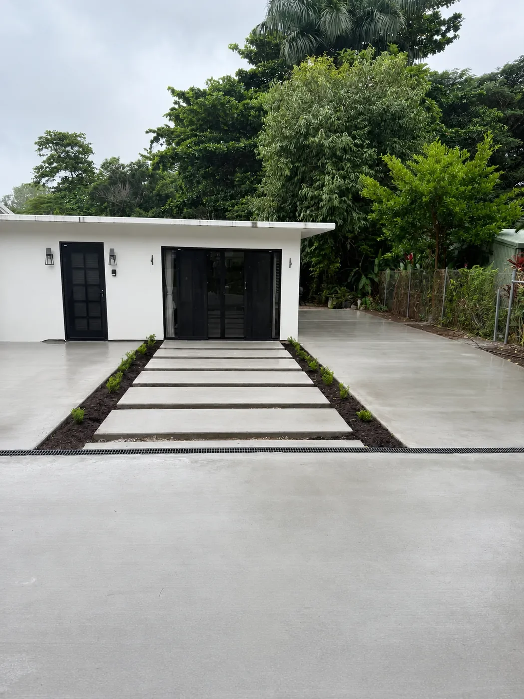 Finished concrete driveway and landscaped entrance at a Cairns home.