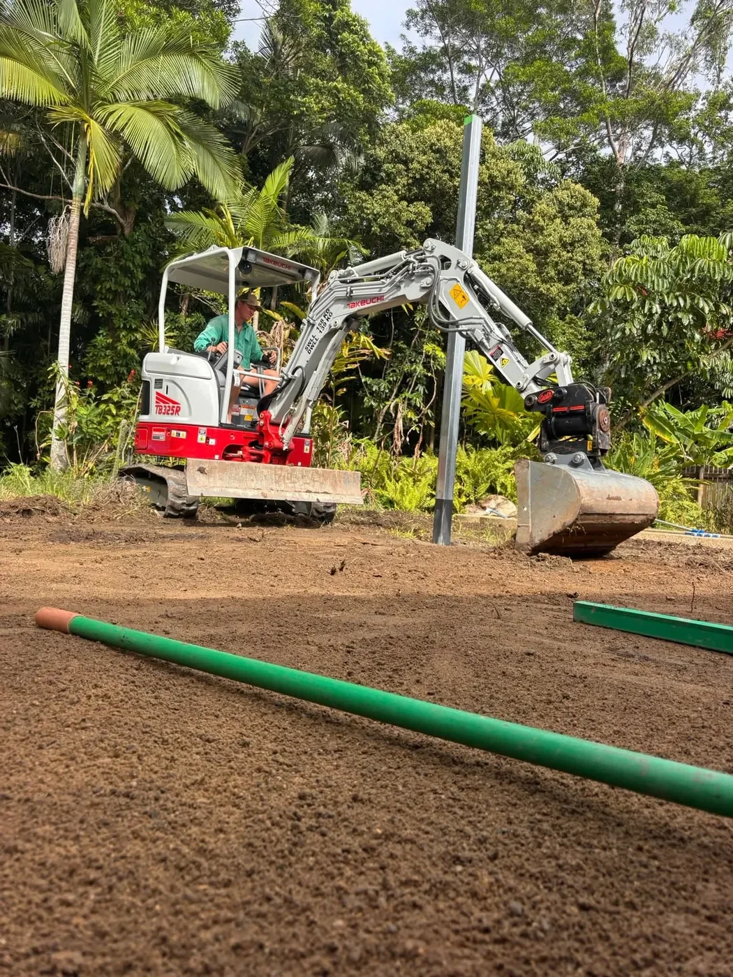 Mini excavator carrying out site preparation and earthmoving work in Far North Queensland.