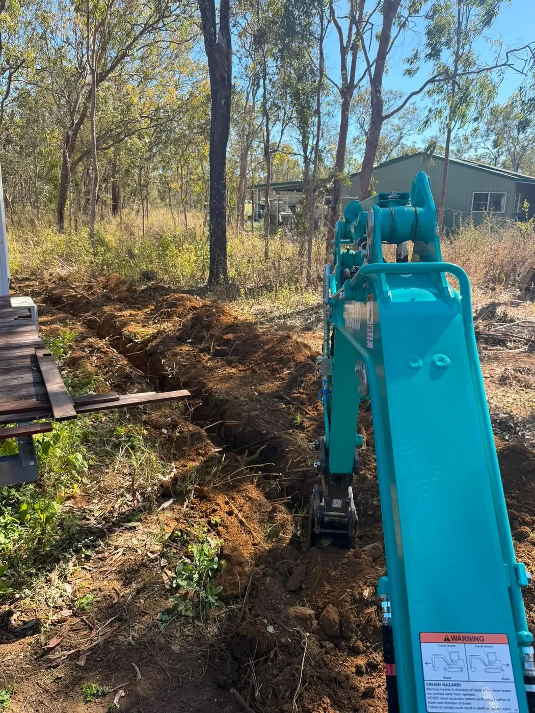 Excavator completing trenching works on a rural property near Mareeba.