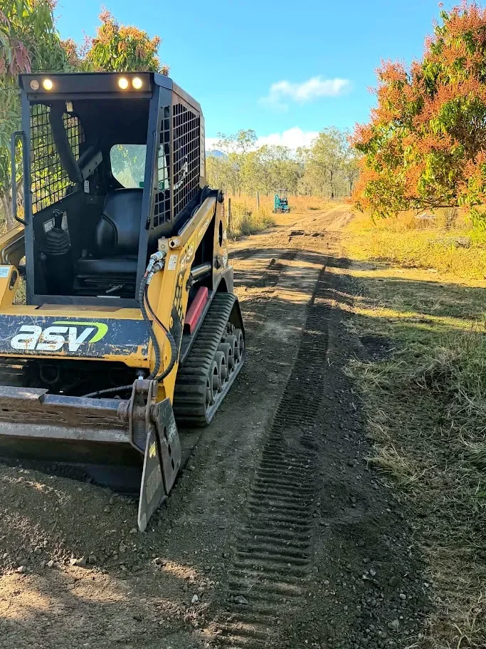 Skid steer preparing and grading a rural driveway near Mareeba.