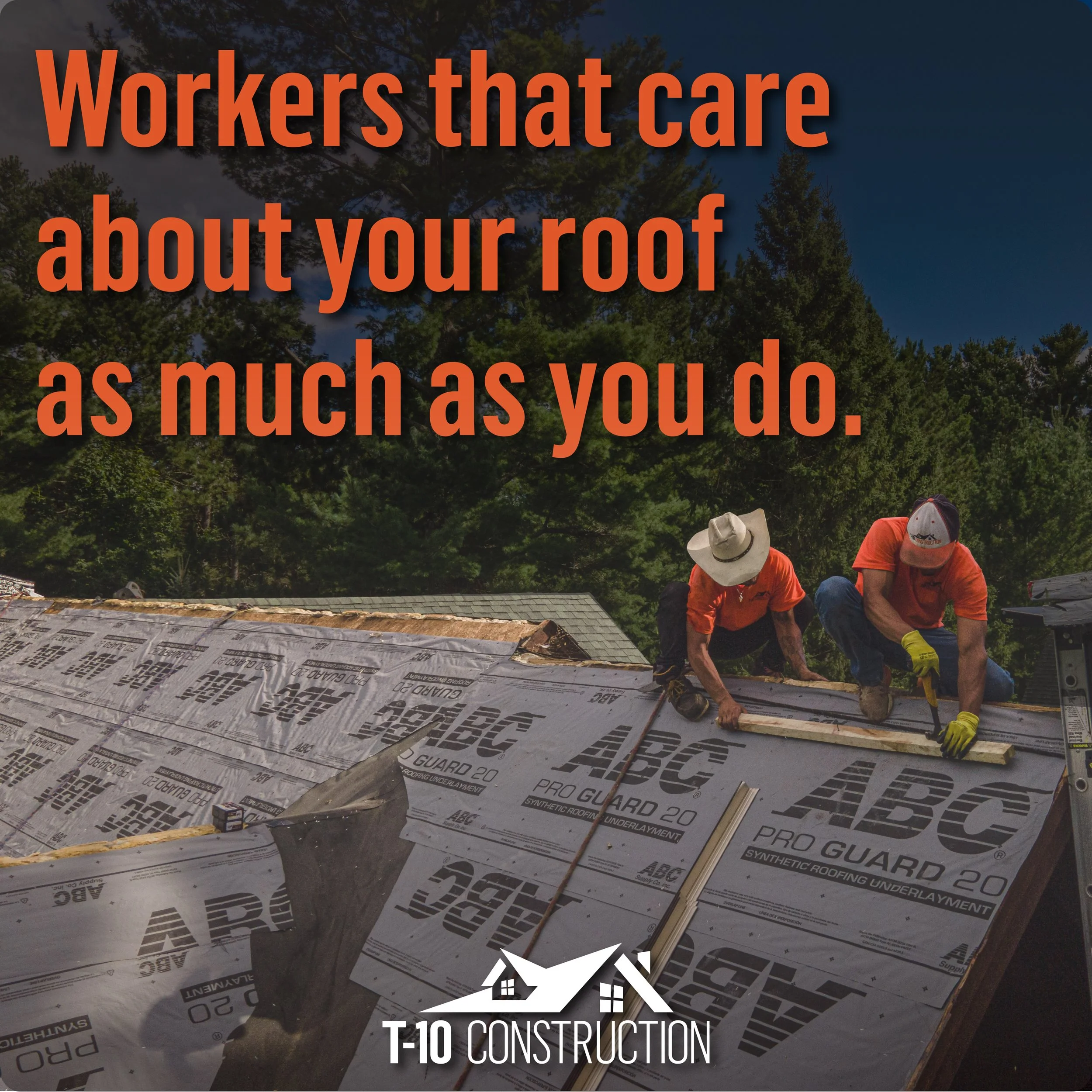 Workers installing synthetic roofing underlayment on a roof, with trees in the background and workers wearing orange shirts and hats.