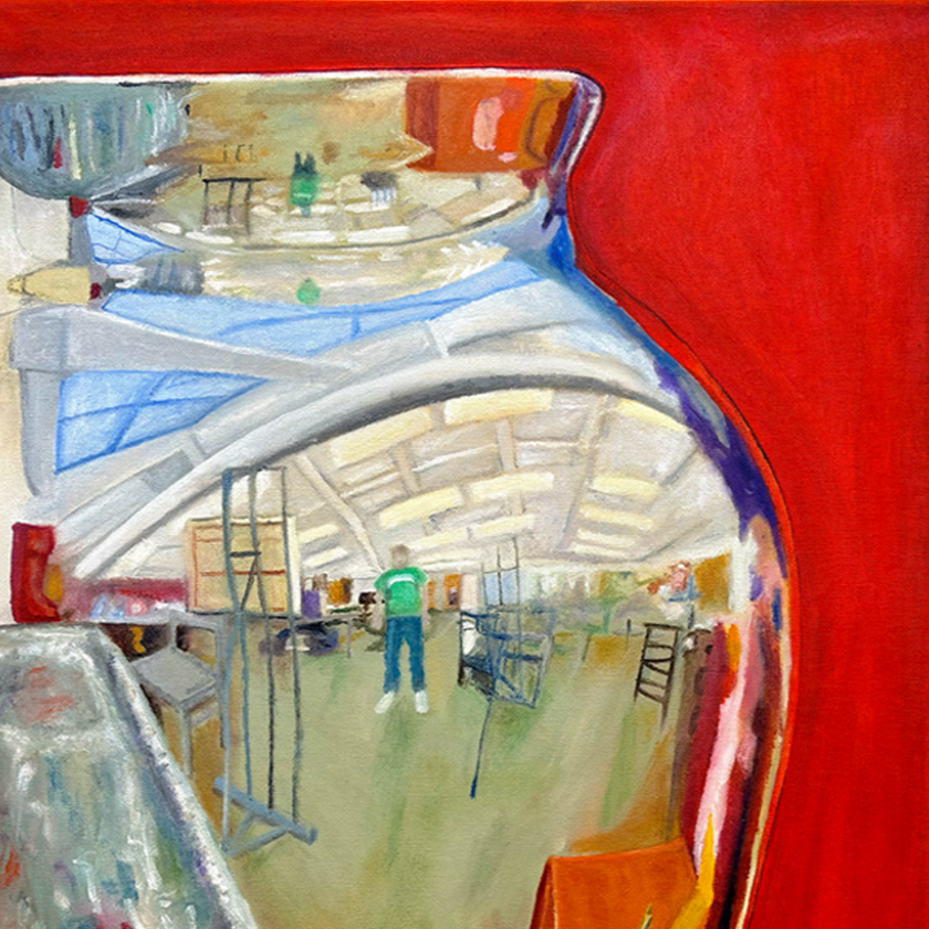Reflection of an art studio interior in the reflection of a vase with a person wearing a green shirt and blue pants standing inside.