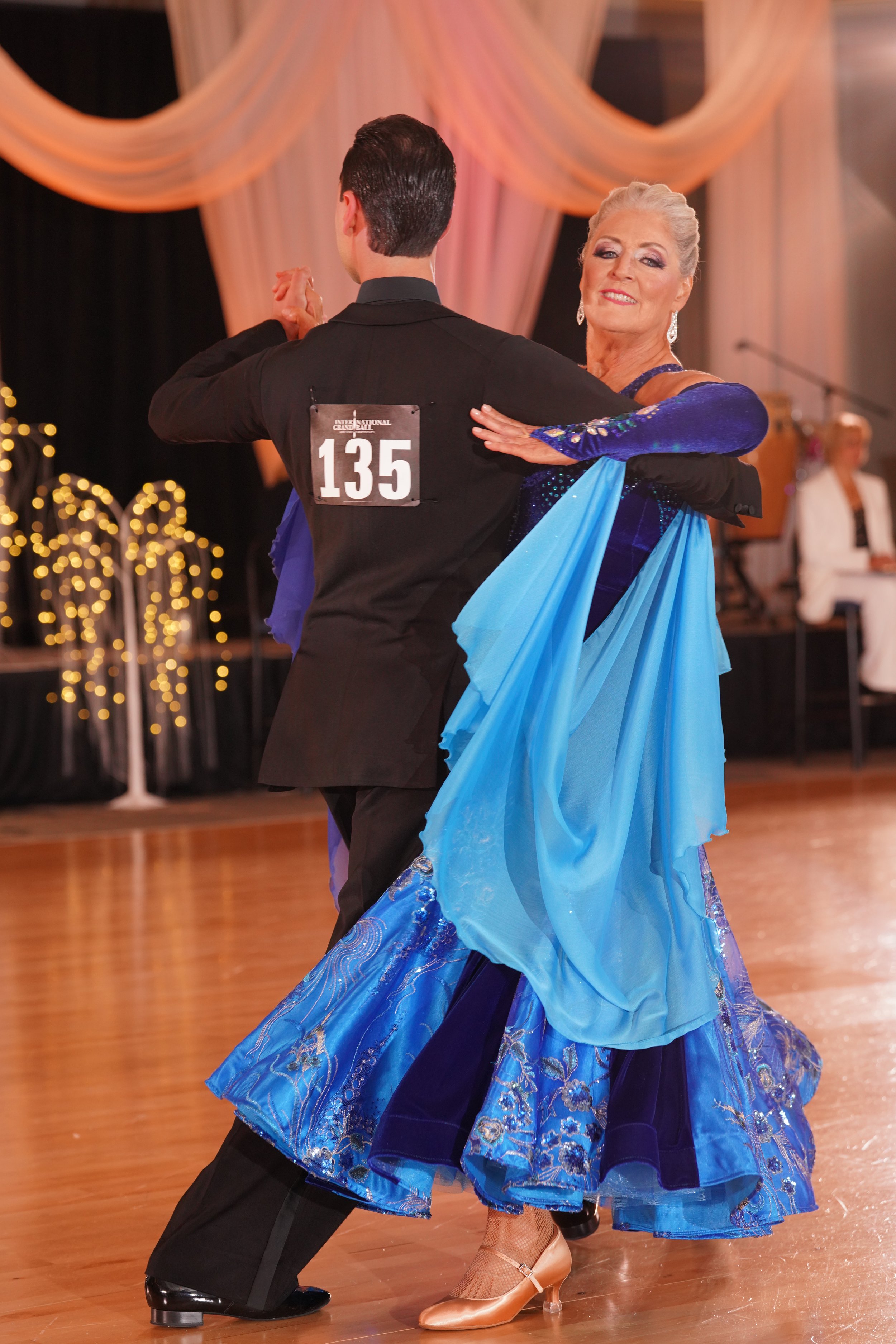 A woman dancing with a man at a ballroom dance event