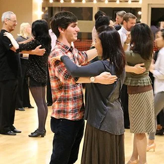 Couples dancing at a social event in a ballroom