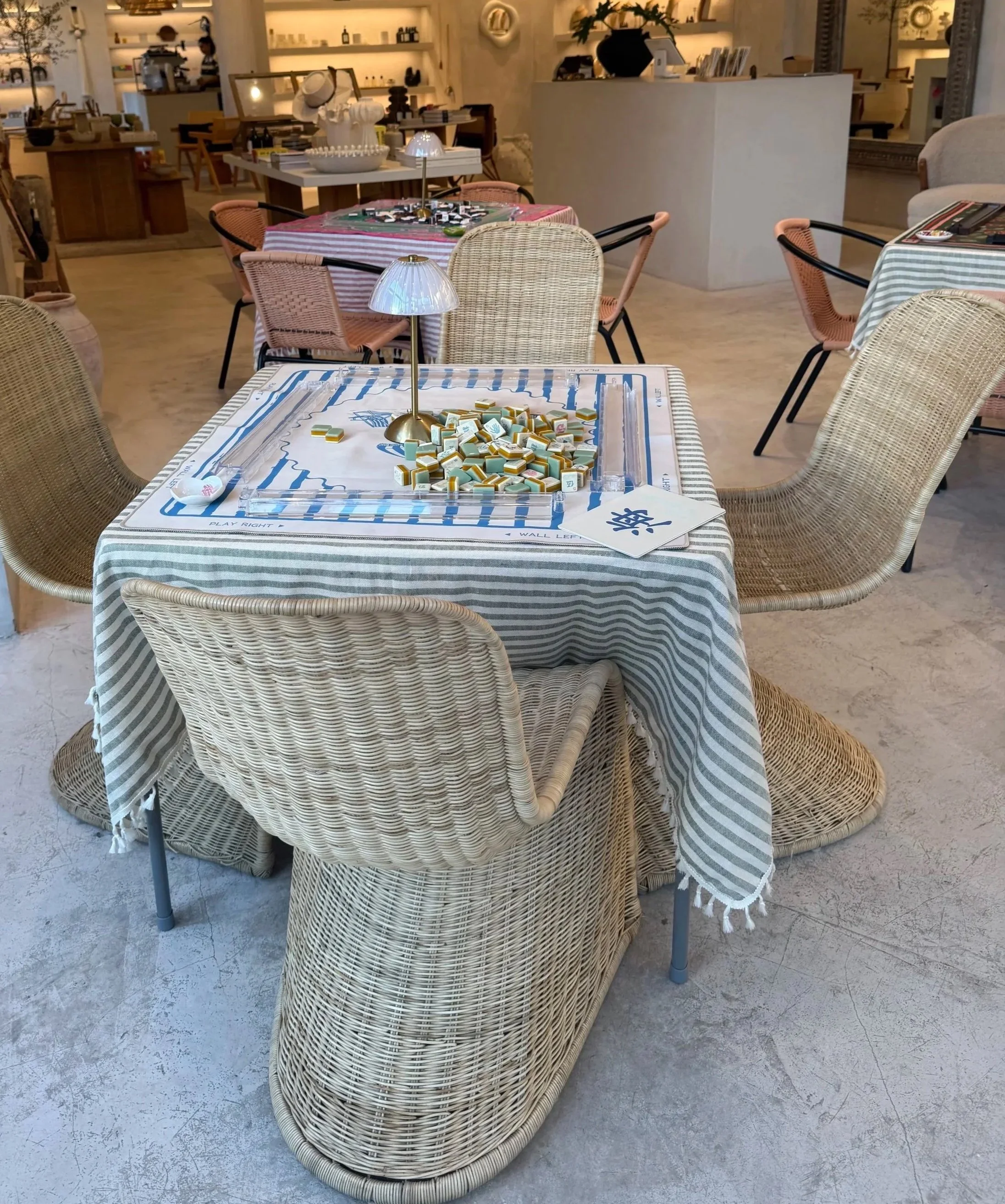 Mahjong table set up in a cozy café-style venue with wicker chairs for a private mahjong event for Mahj & Mingle in Chicago