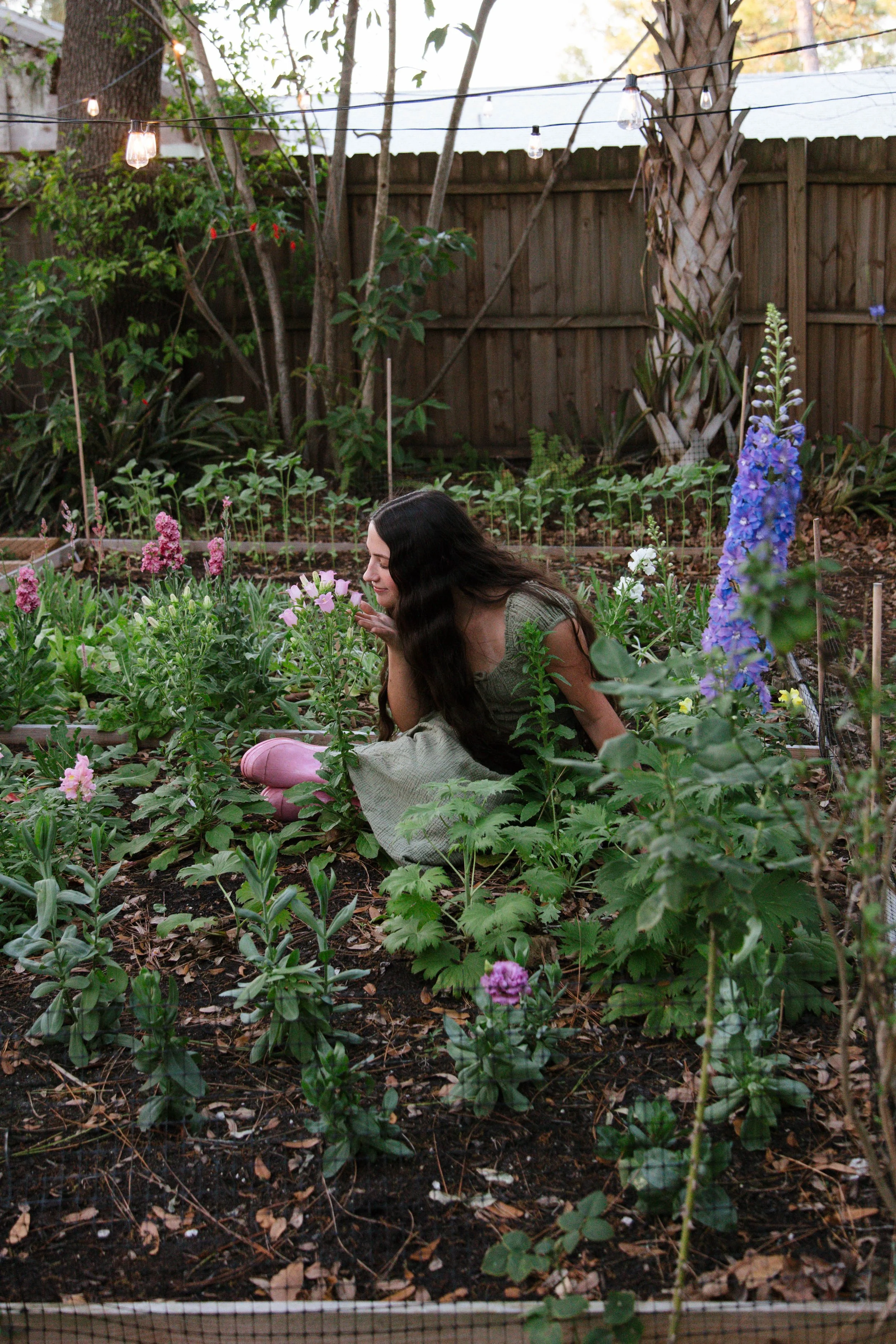 A girl smelling flowers in a garden