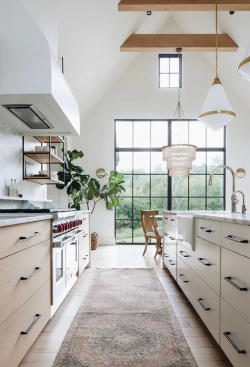 Castle Pines kitchen with white cabinetry, exposed wood beams, and natural light.