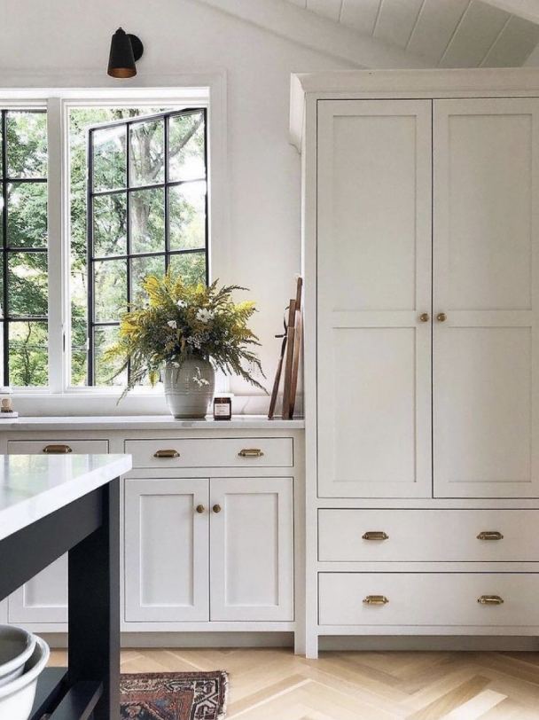 Castle Pines kitchen with white cabinetry, large island, and arched windows in luxury renovation.
