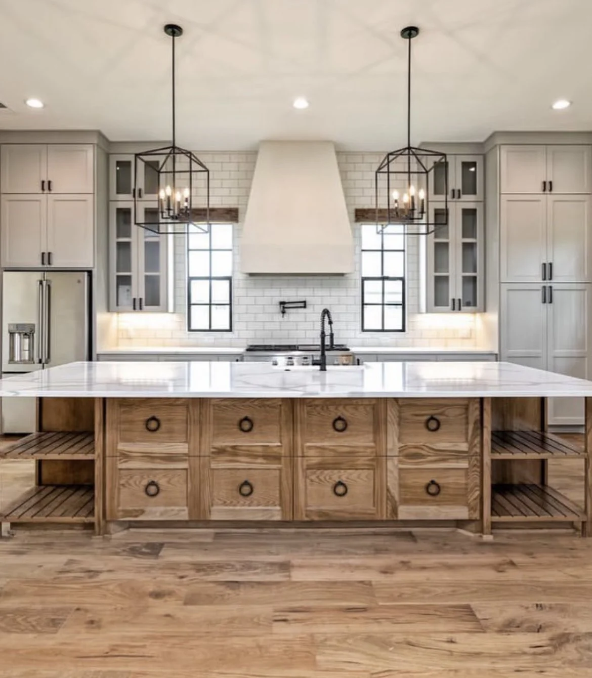 Castle Rock kitchen with marble island, white cabinetry, brick backsplash, and pendant lighting.