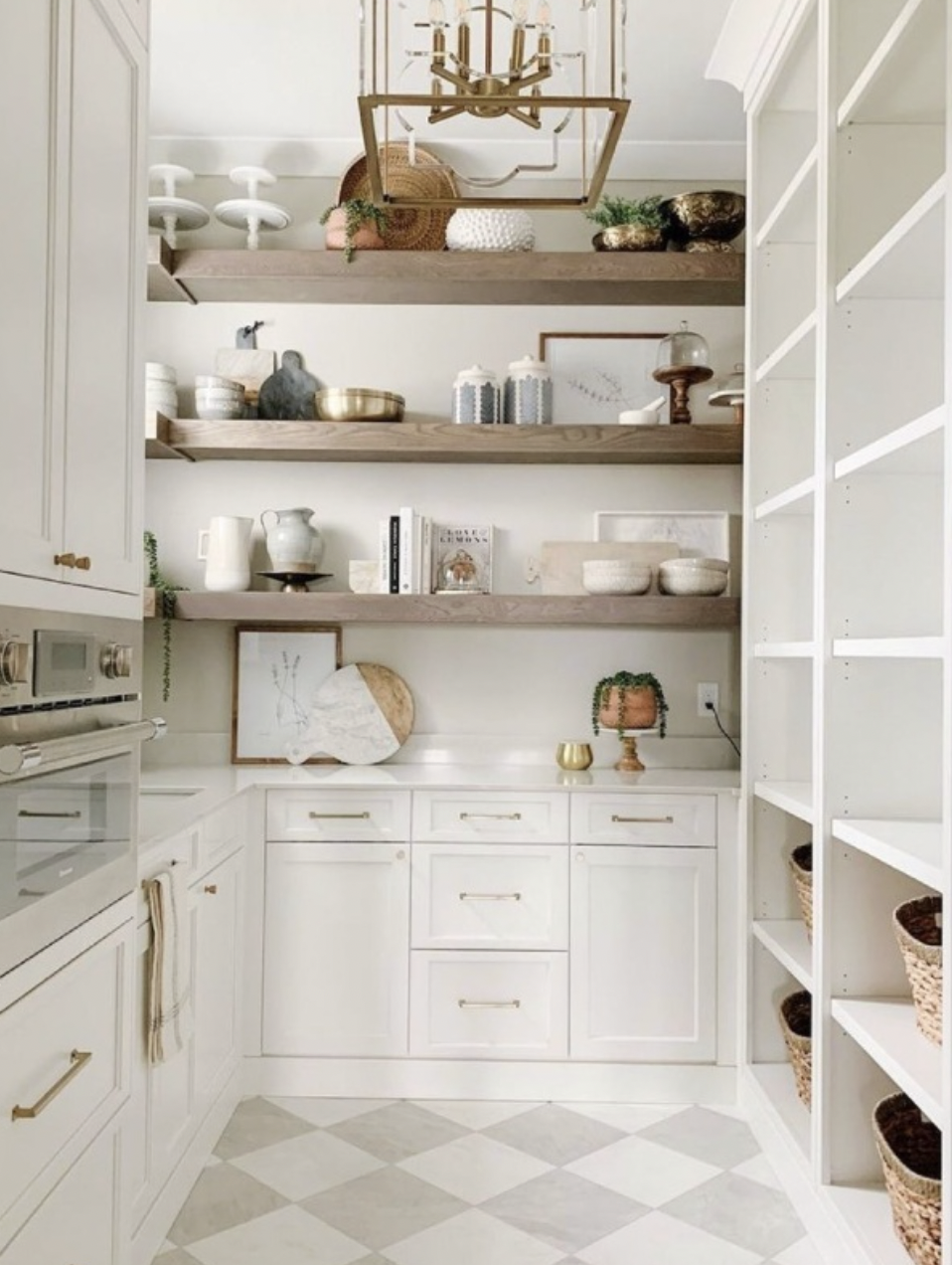 Castle Pines butler's pantry with open shelving, brass chandelier, and checkered tile floor.