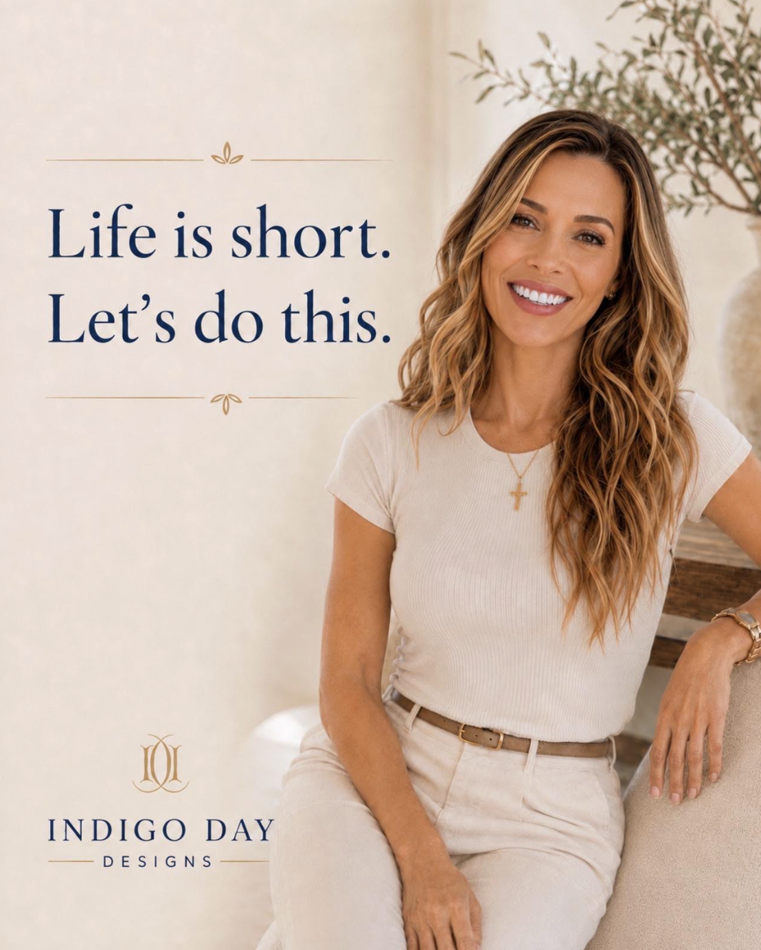 A smiling woman with long curly hair wearing a white t-shirt and beige pants, sitting next to a table with a plant in the background. Overlaid text reads 'Life is short. Let's do this.' with 'Indigo Day Designs' logo at the bottom.