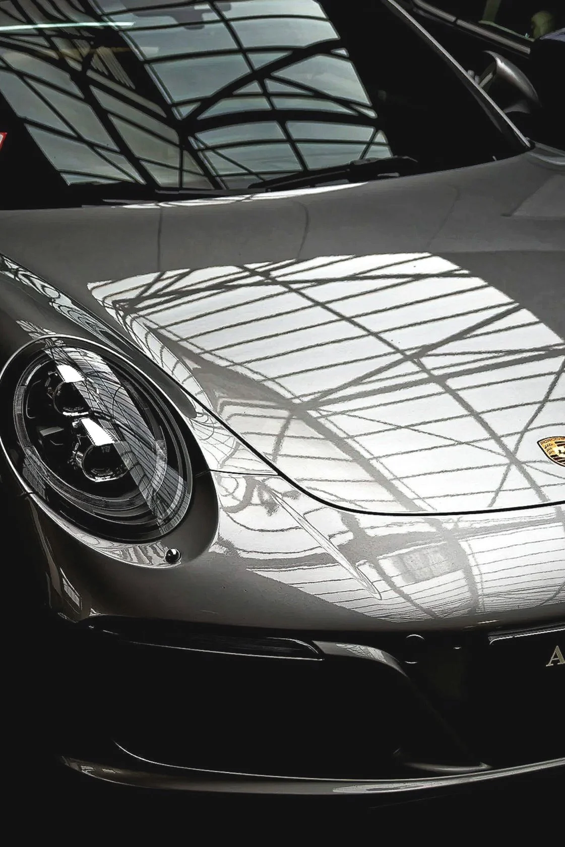 Glossy Porsche exterior with ceramic coating showing deep shine and mirror-like reflection after detailing