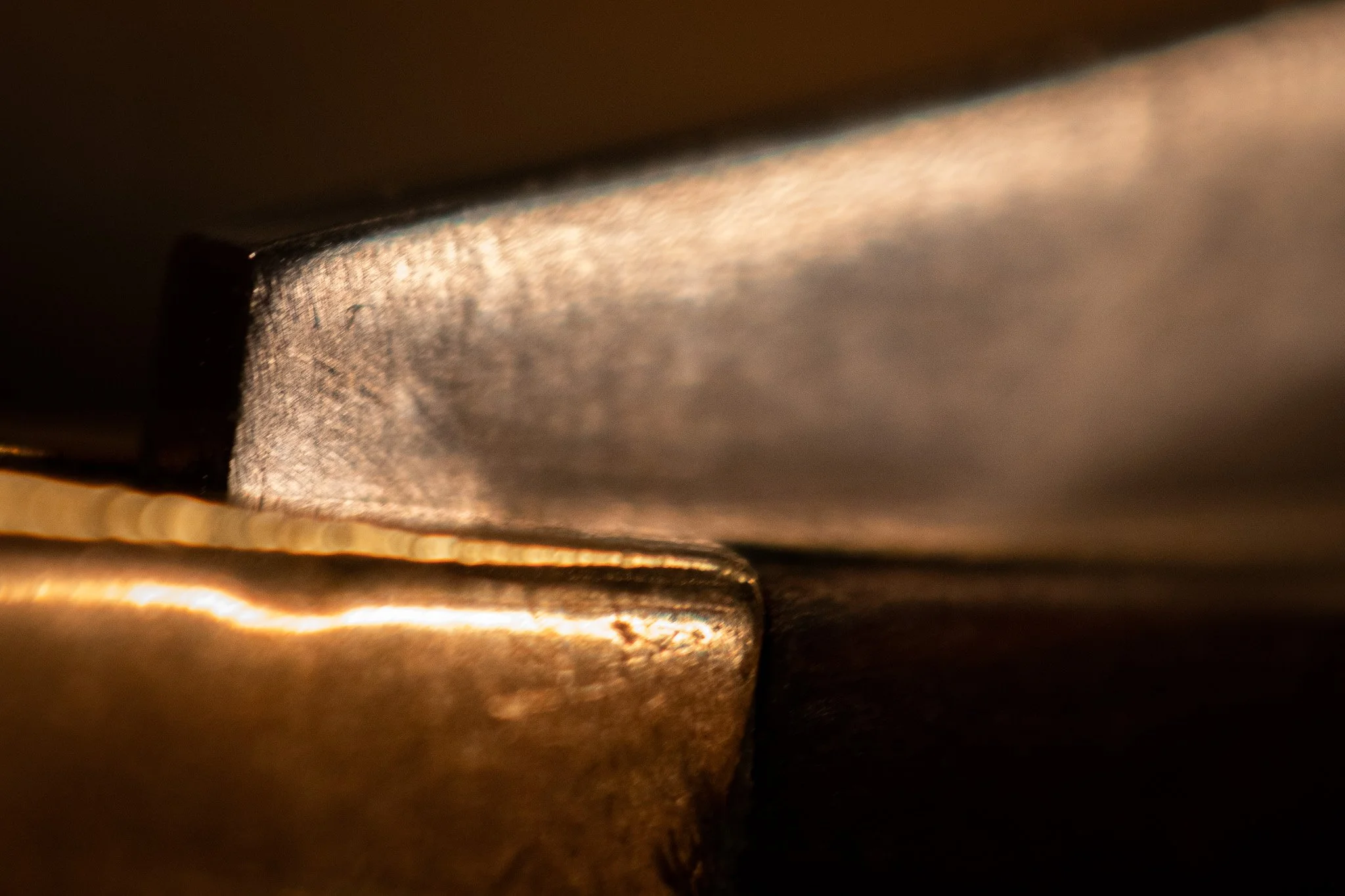 Close-up of the edges of metallic objects with a reflective surface and textured appearance, layered and stacked.