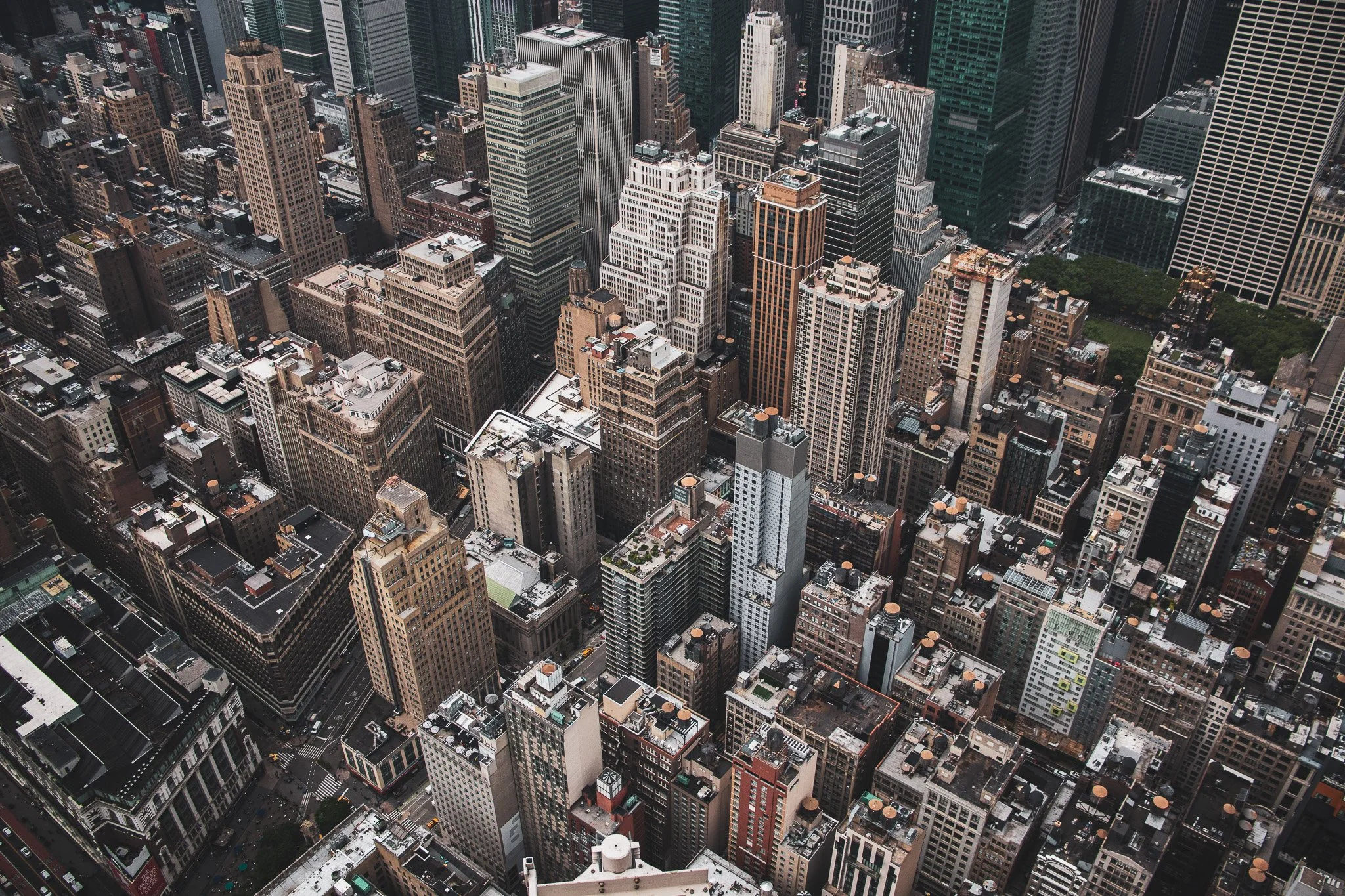 Aerial view of a dense cityscape with tall skyscrapers, office buildings, and streets in a metropolitan area.