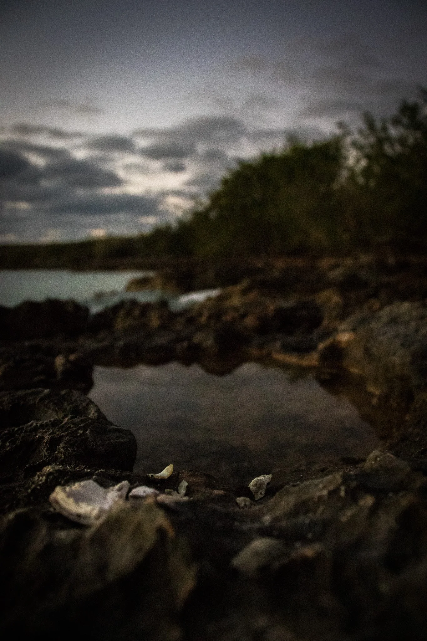 Rock formation with a cloudy sky and reflection on water.