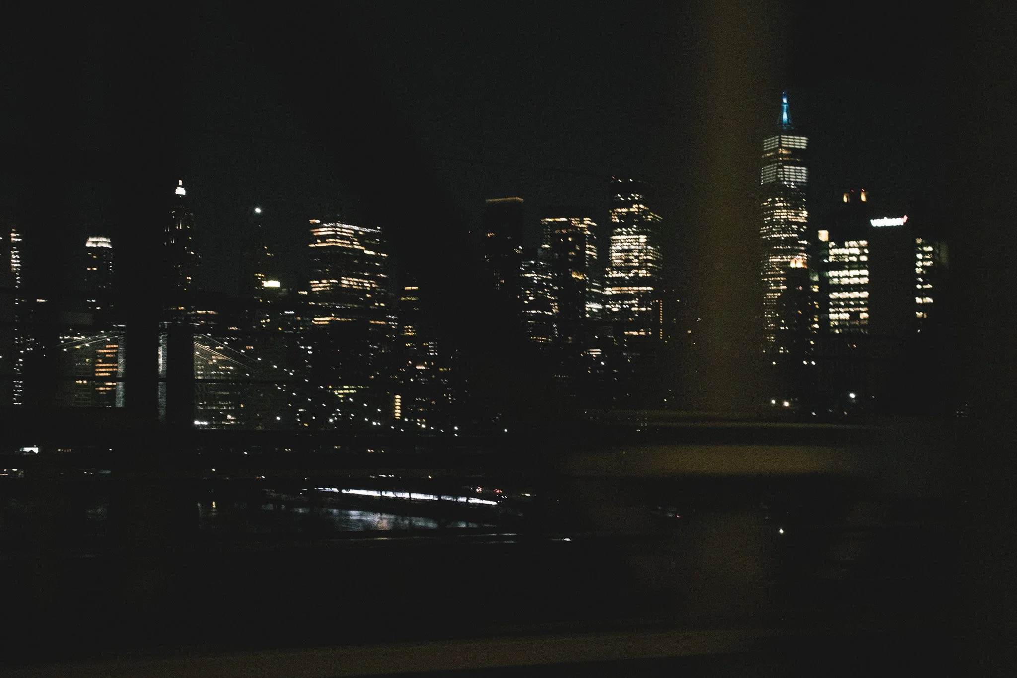 Nighttime city skyline with illuminated skyscrapers and a dark sky.