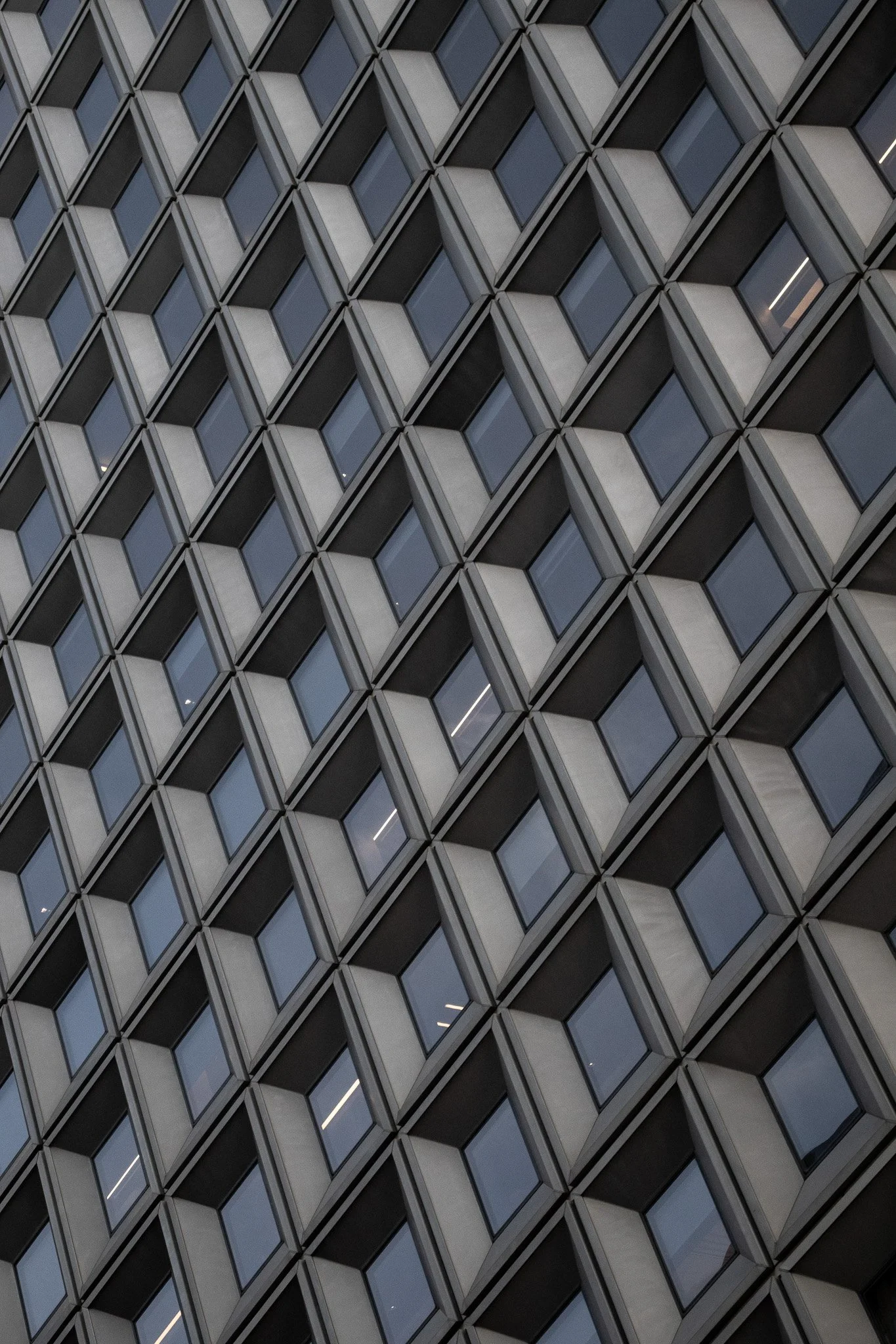 Close-up view of a modern building facade with a geometric pattern of square and rectangular windows.