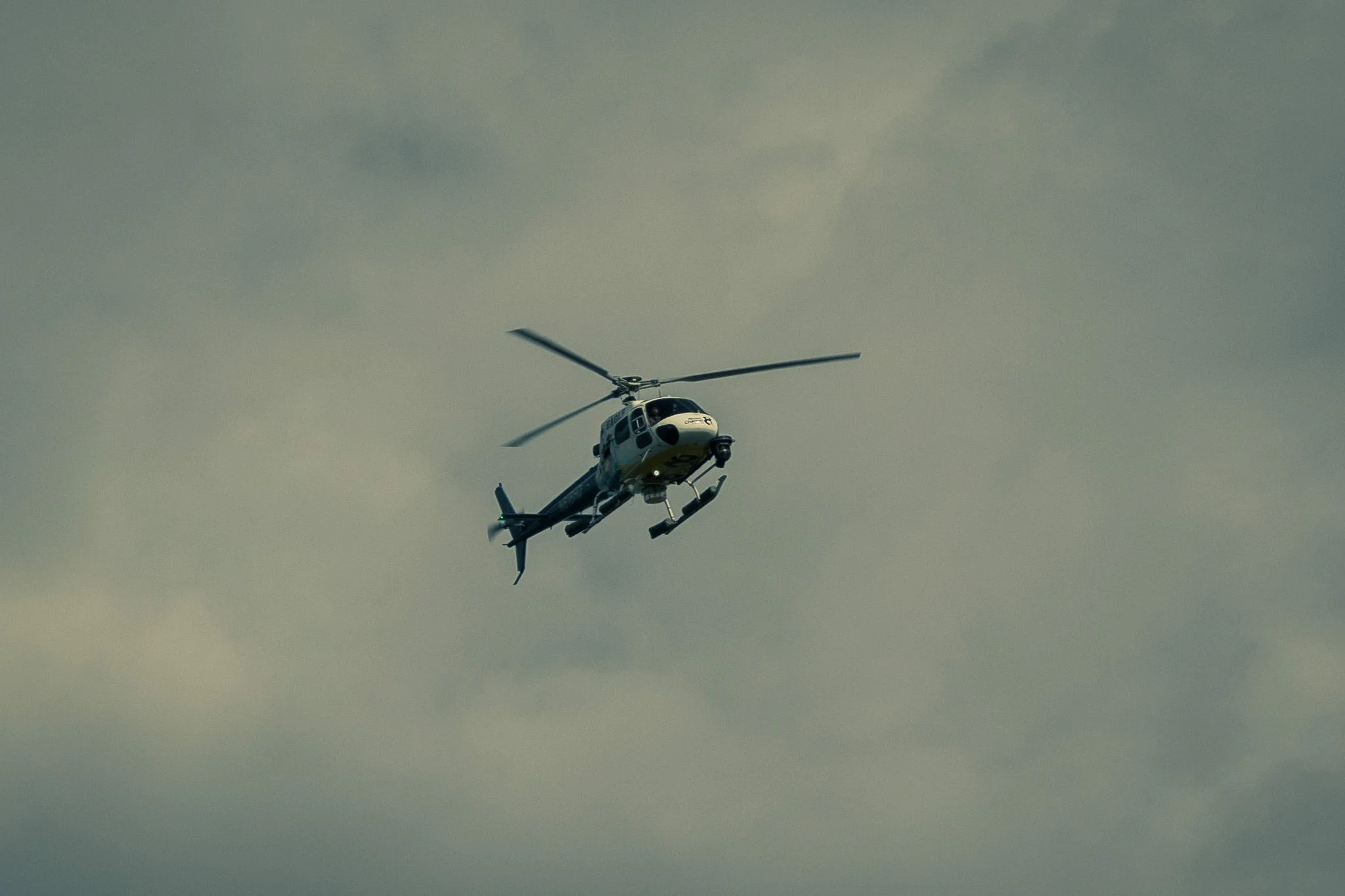 A helicopter flying in a cloudy sky.