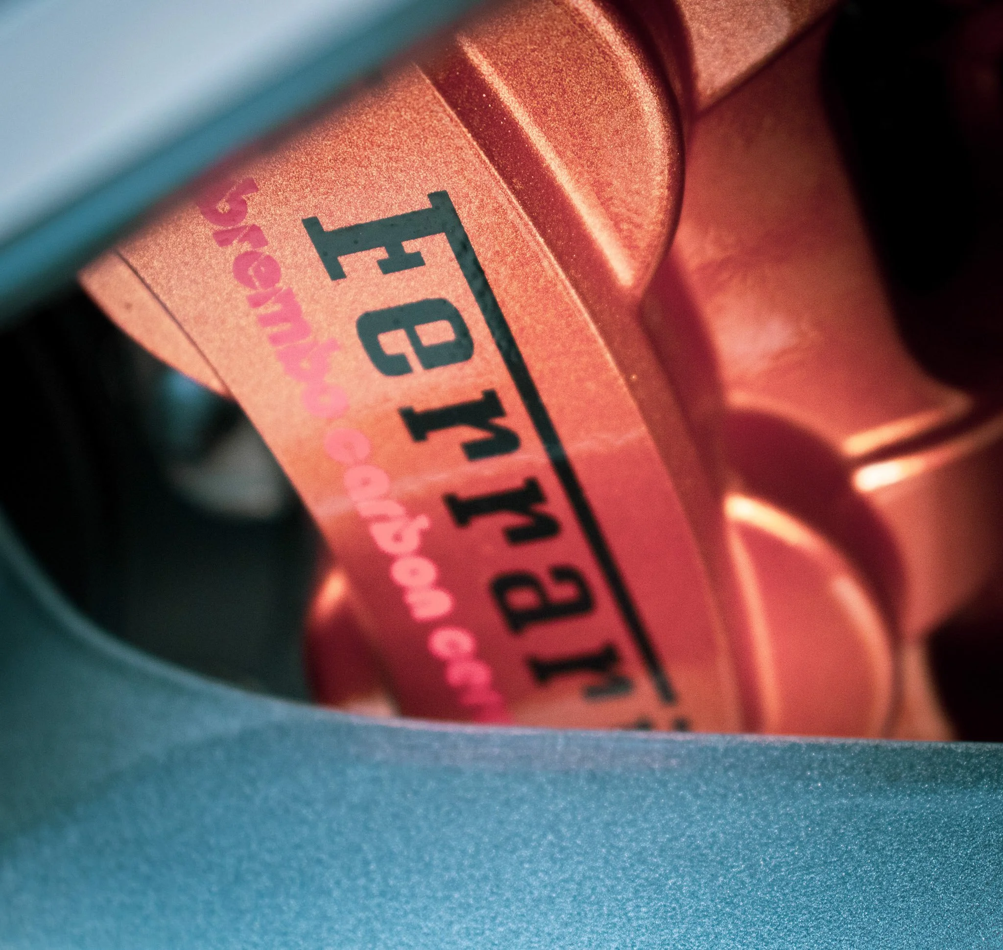 Close-up view of a peach-colored pill with black and pink text printed on it, resting on a blue surface.