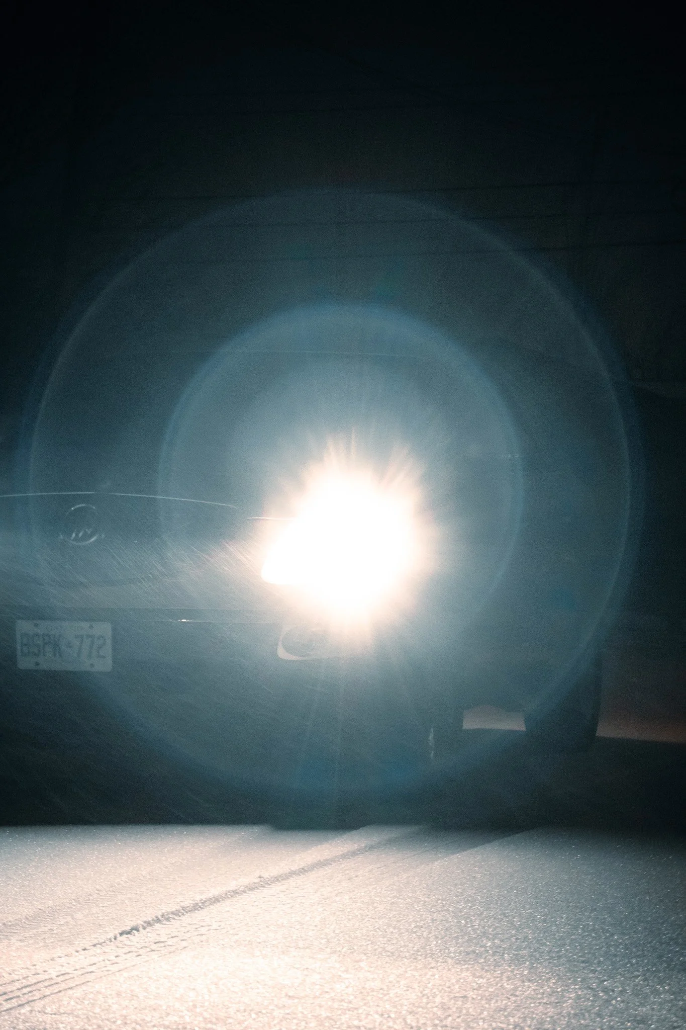 Bright sunlight reflecting off a road viewed from inside a car.