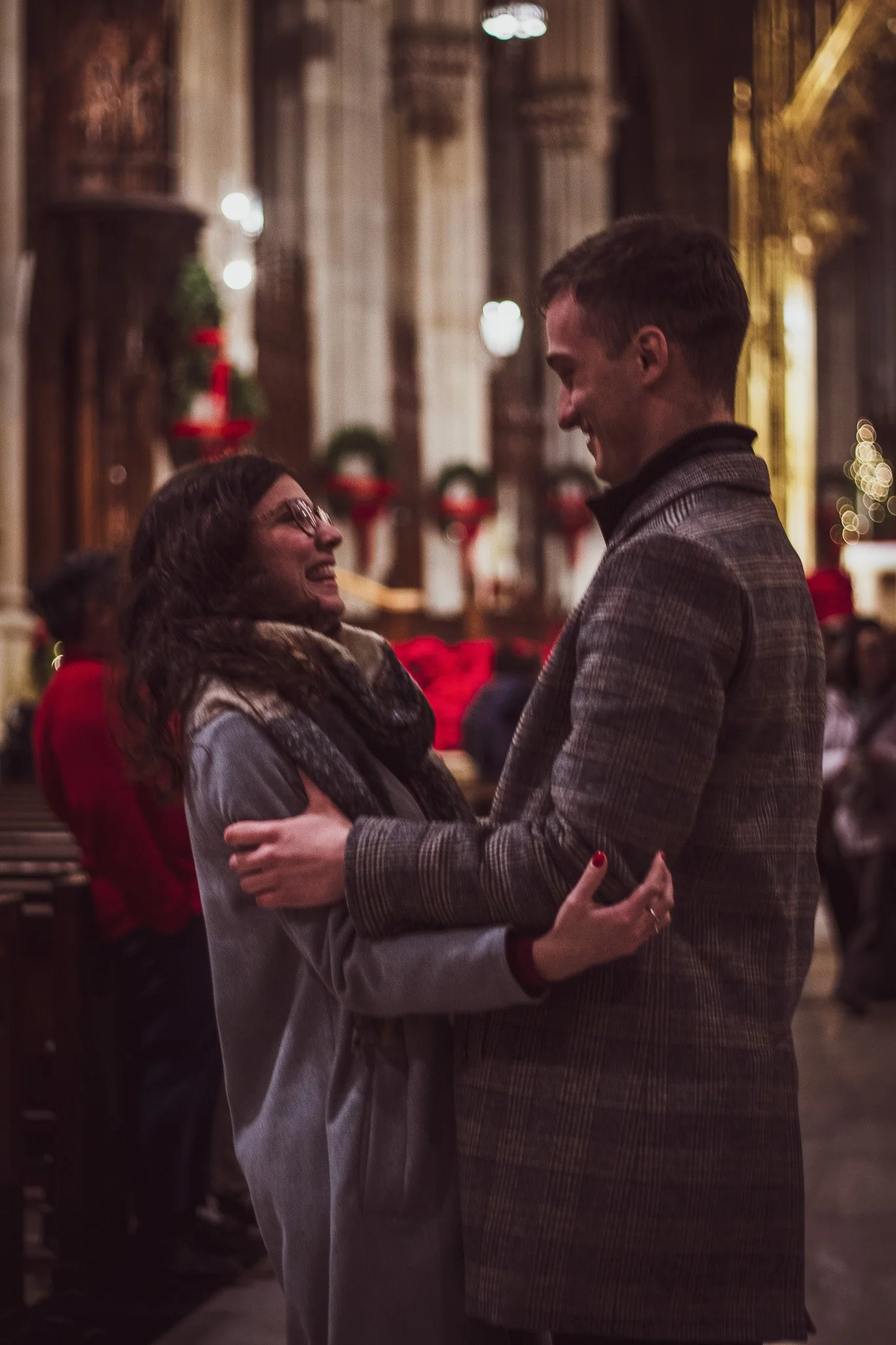 A man and woman dancing closely in a warmly lit, decorated indoor setting at Christmas time.