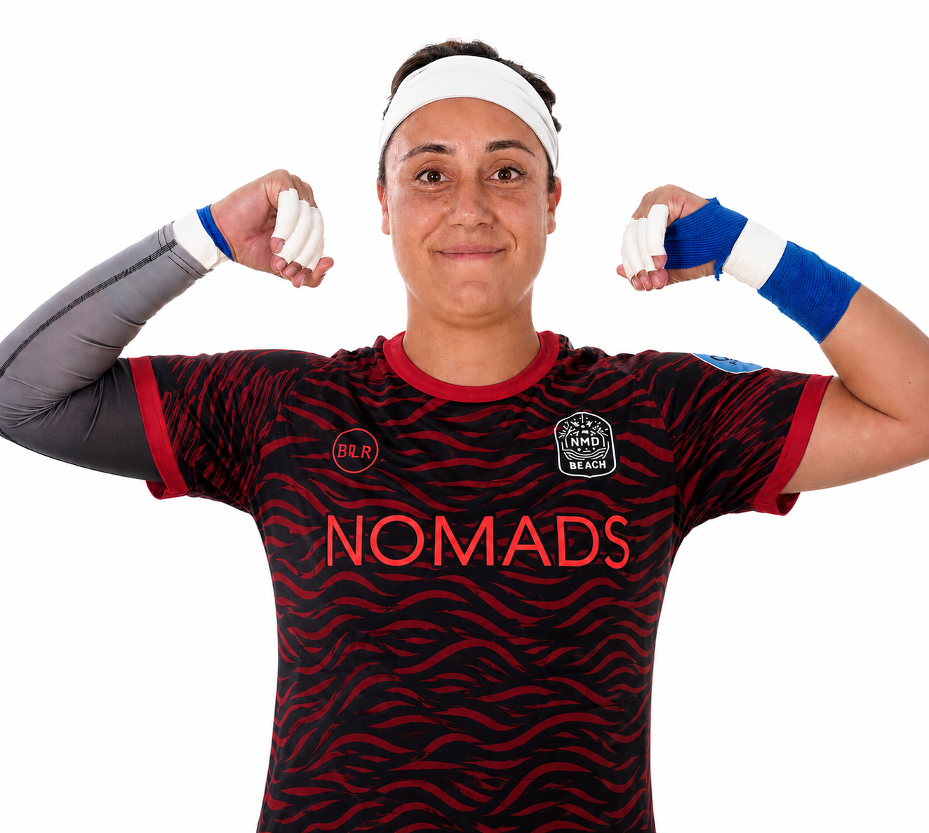 A woman wearing a sports jersey and headband, flexing her biceps, with athletic tape on her hands and wrists.