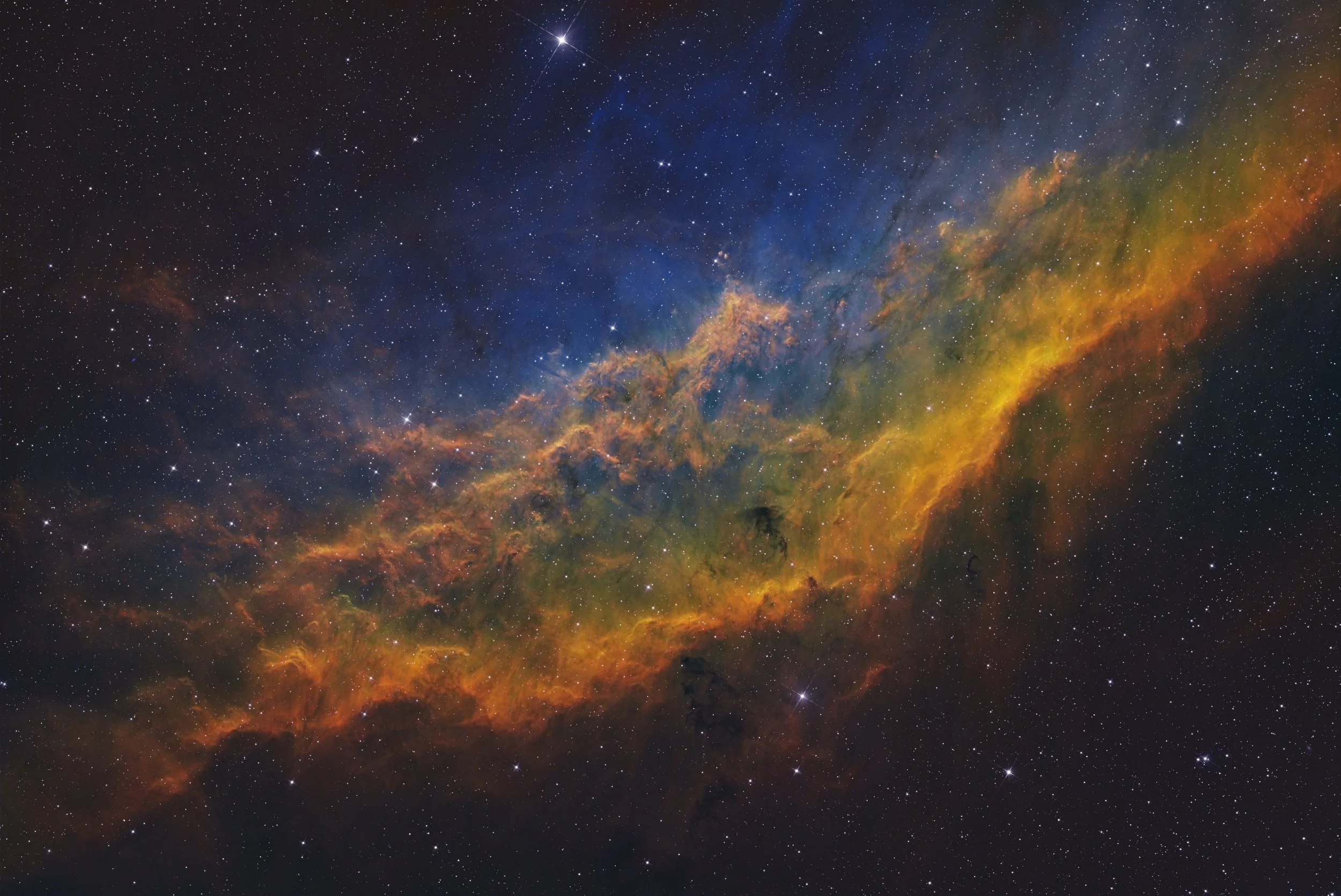 A colorful image of a galaxy with stars and nebulae in space, showing a bright, multicolored cosmic cloud with yellow, orange, green, blue, and purple hues.