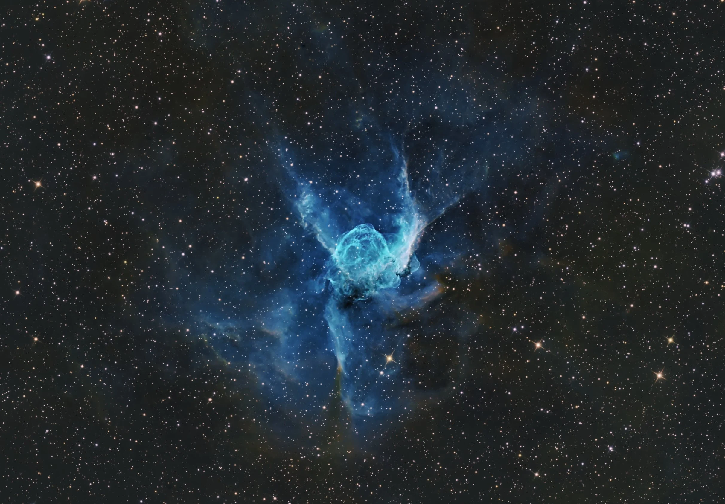 A deep space image showing a nebula with a blue and white cloud-like formation surrounded by numerous small stars across the black background of space.