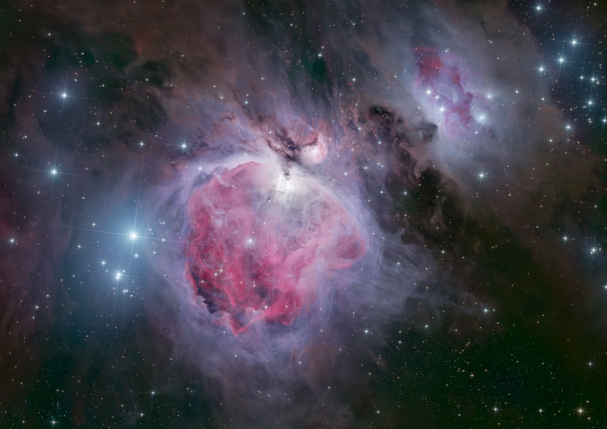 A colorful image of a galaxy with stars, nebulae, and cosmic clouds in shades of pink, purple, black, and blue.