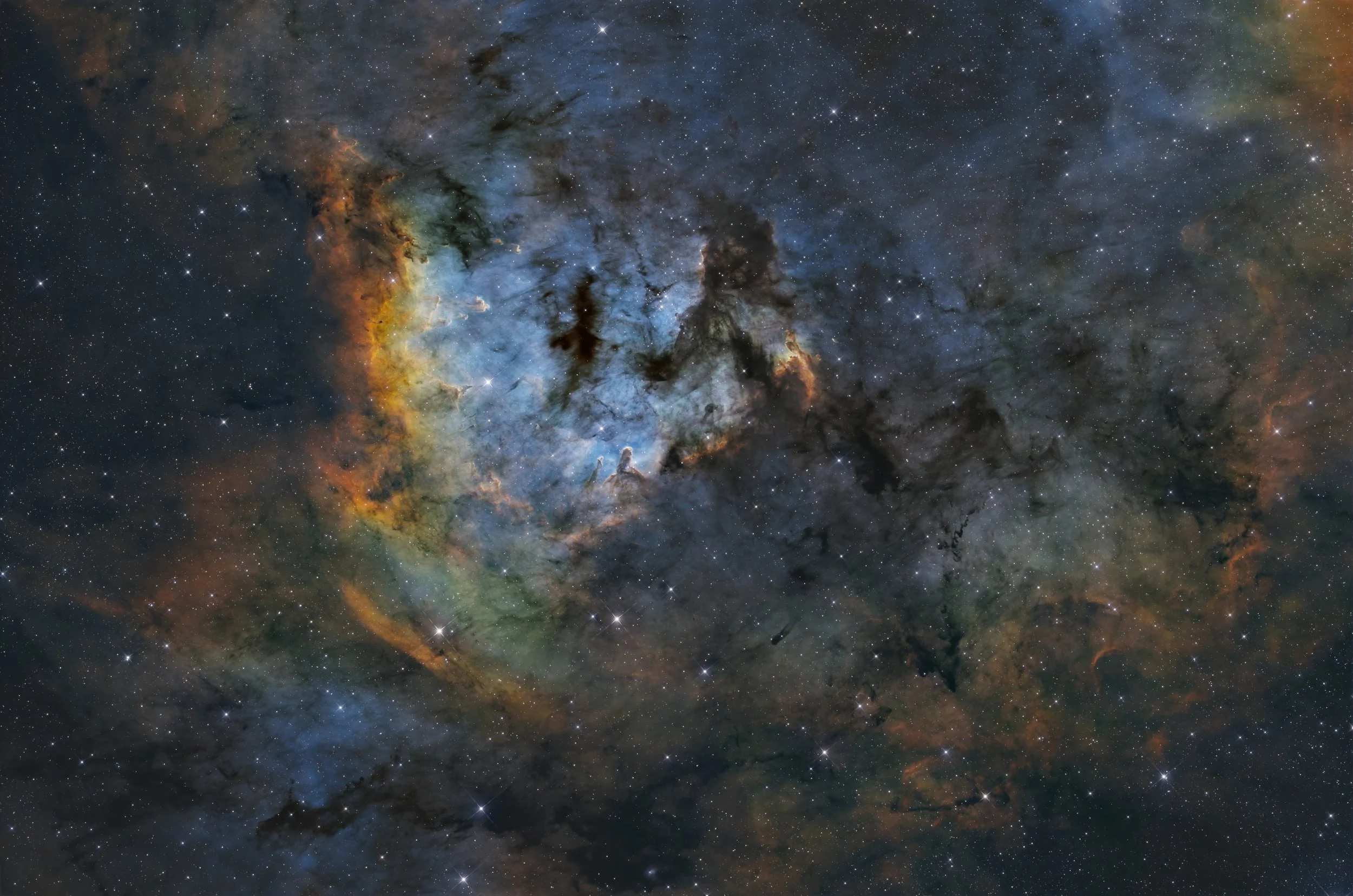 A vibrant image of a colorful nebula in outer space, filled with stars and dark cosmic clouds.