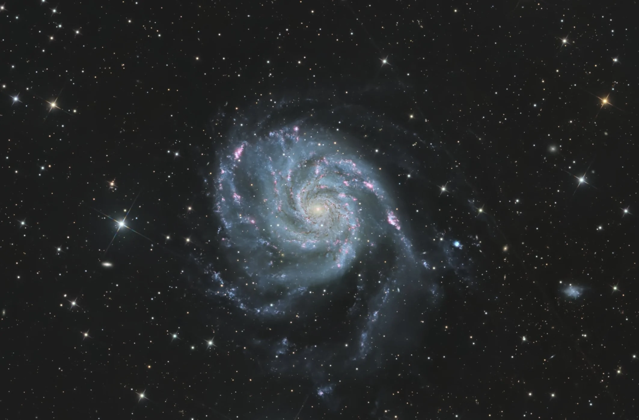 A photograph of a galaxy with swirling arms, surrounded by numerous stars and cosmic dust in space.